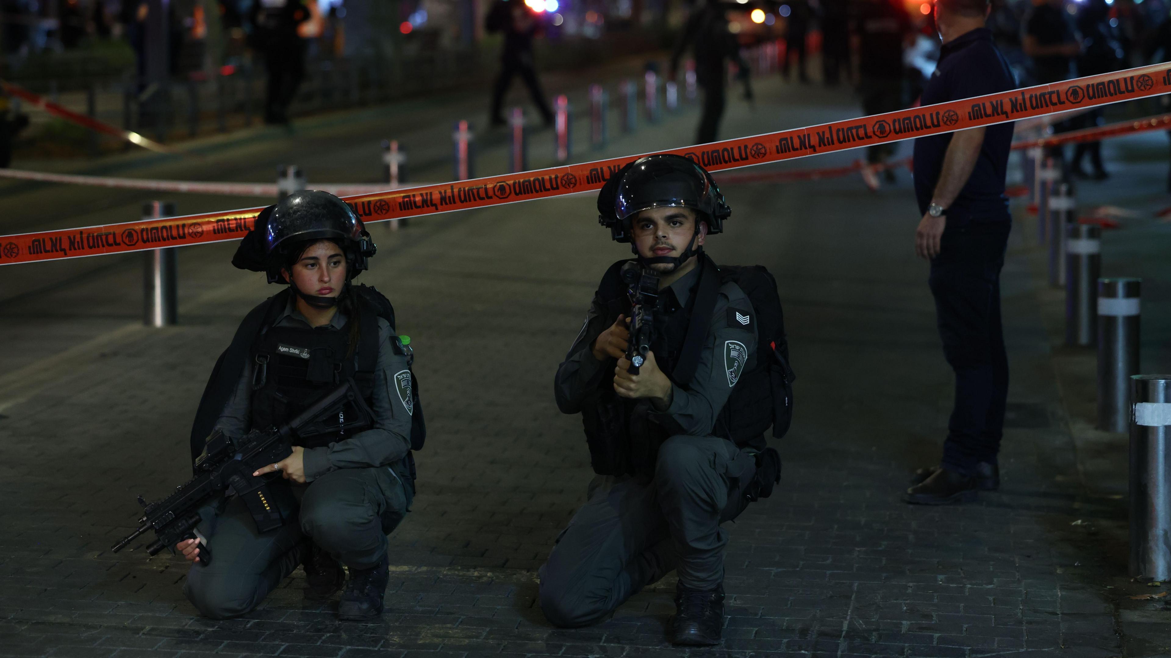 Armed police officers guard a cordon