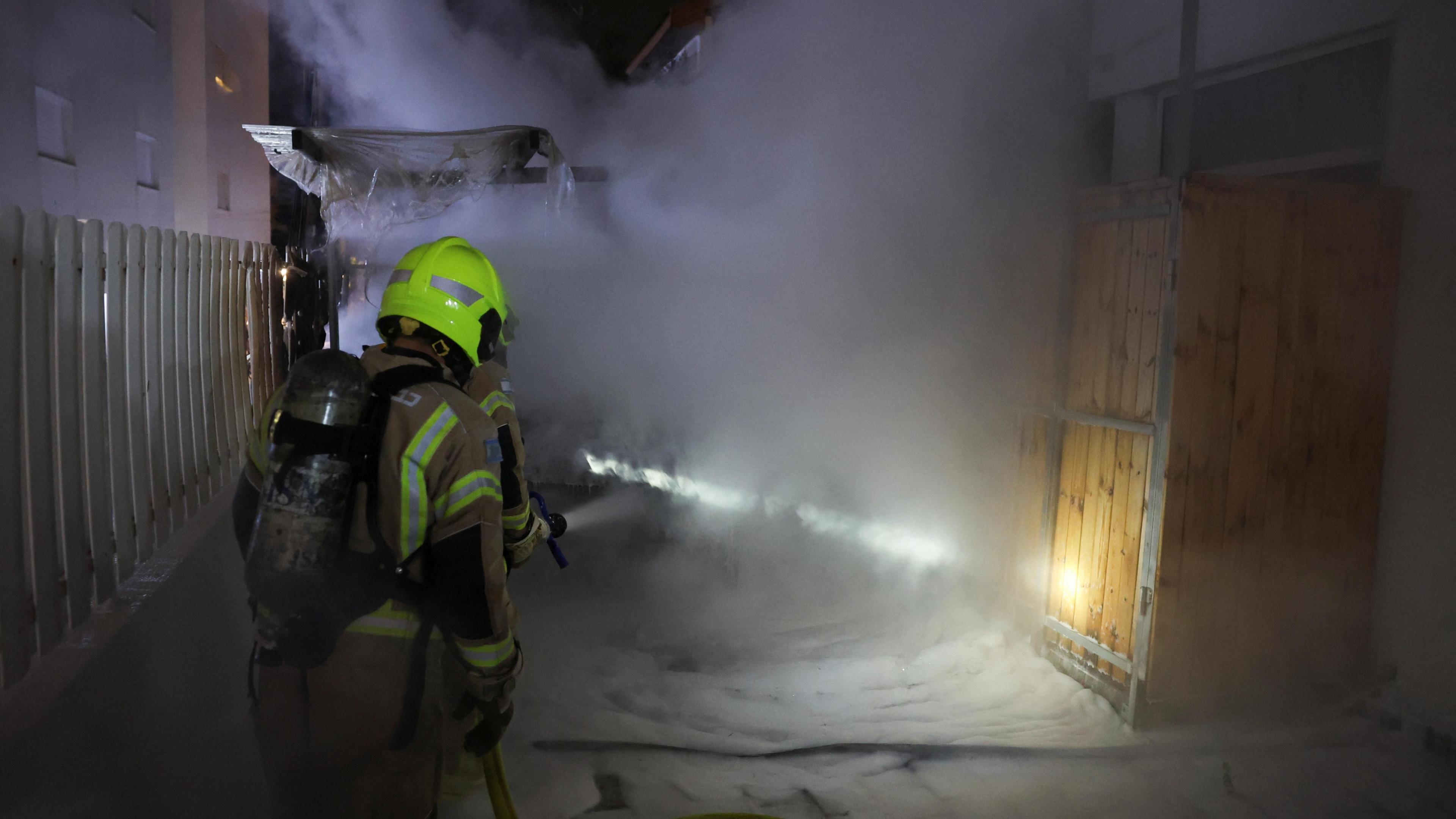 Firefighters work at the site of a rocket impact in Nahariya, Israel (26 November 2024)