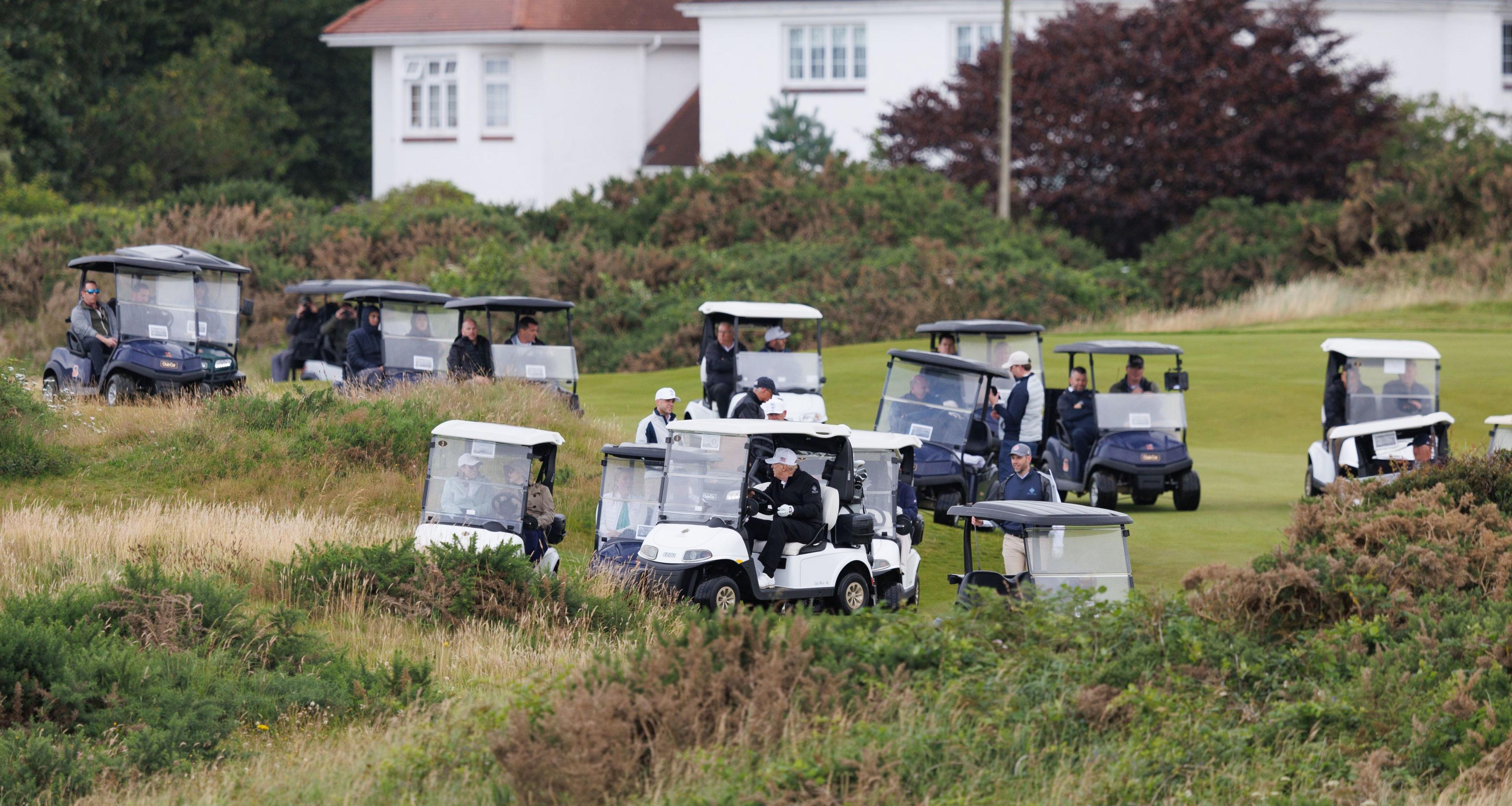 Donald Trump leading a convoy of 15 other golf buggies