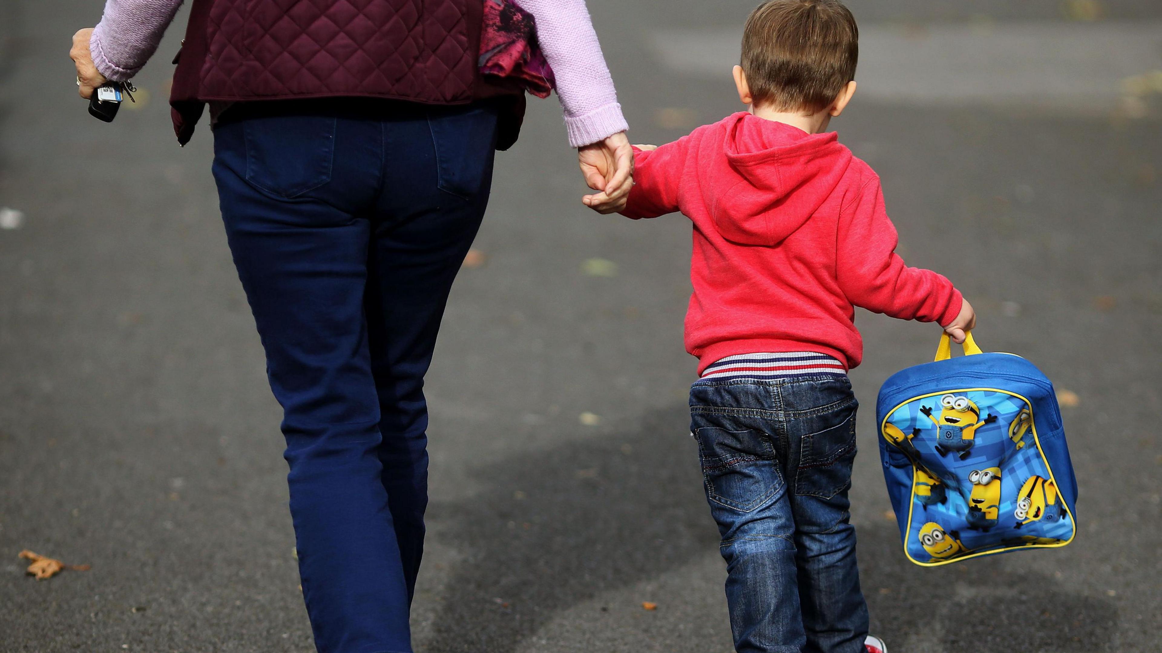 A generic image of a woman and a child with a school bag