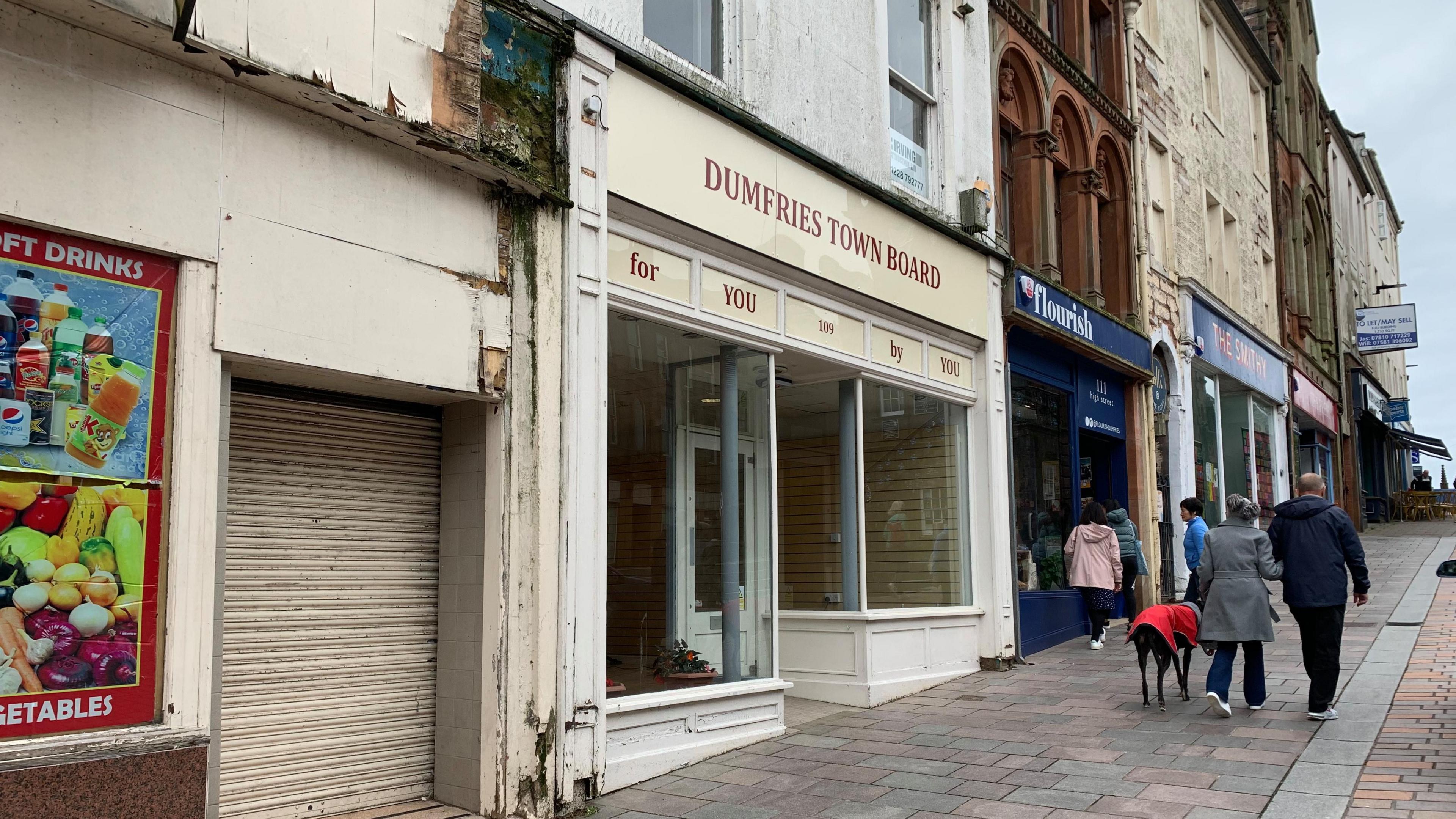 A building in Dumfries town centre used by its town board with pedestrians walking past