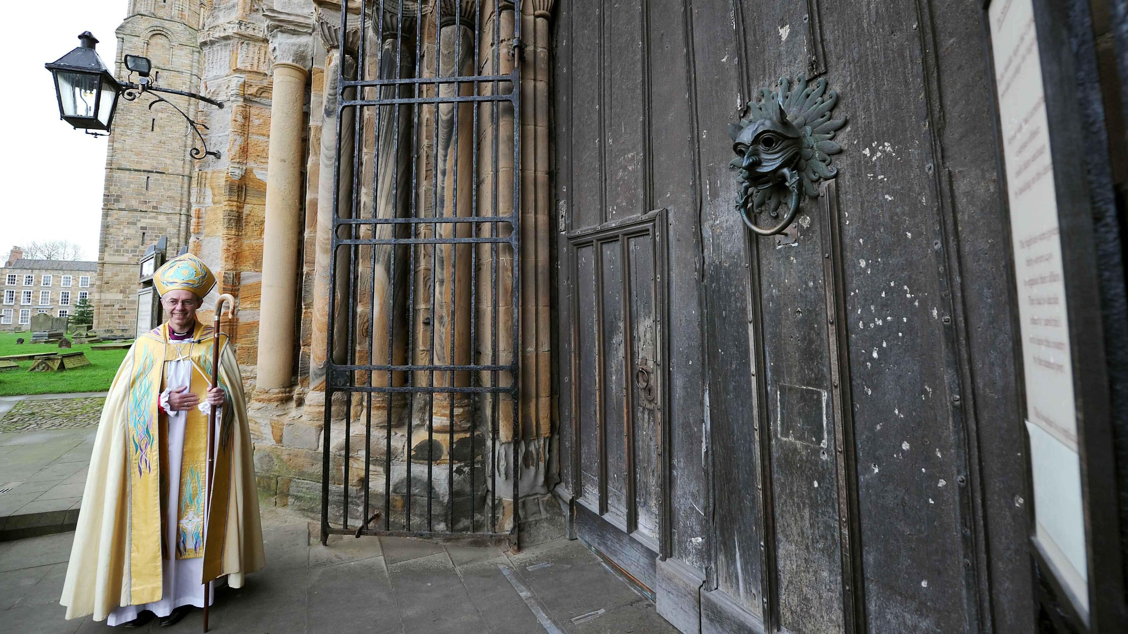 Justin Welby outside Durham Cathedral wearing church clothes and holding a crozier.