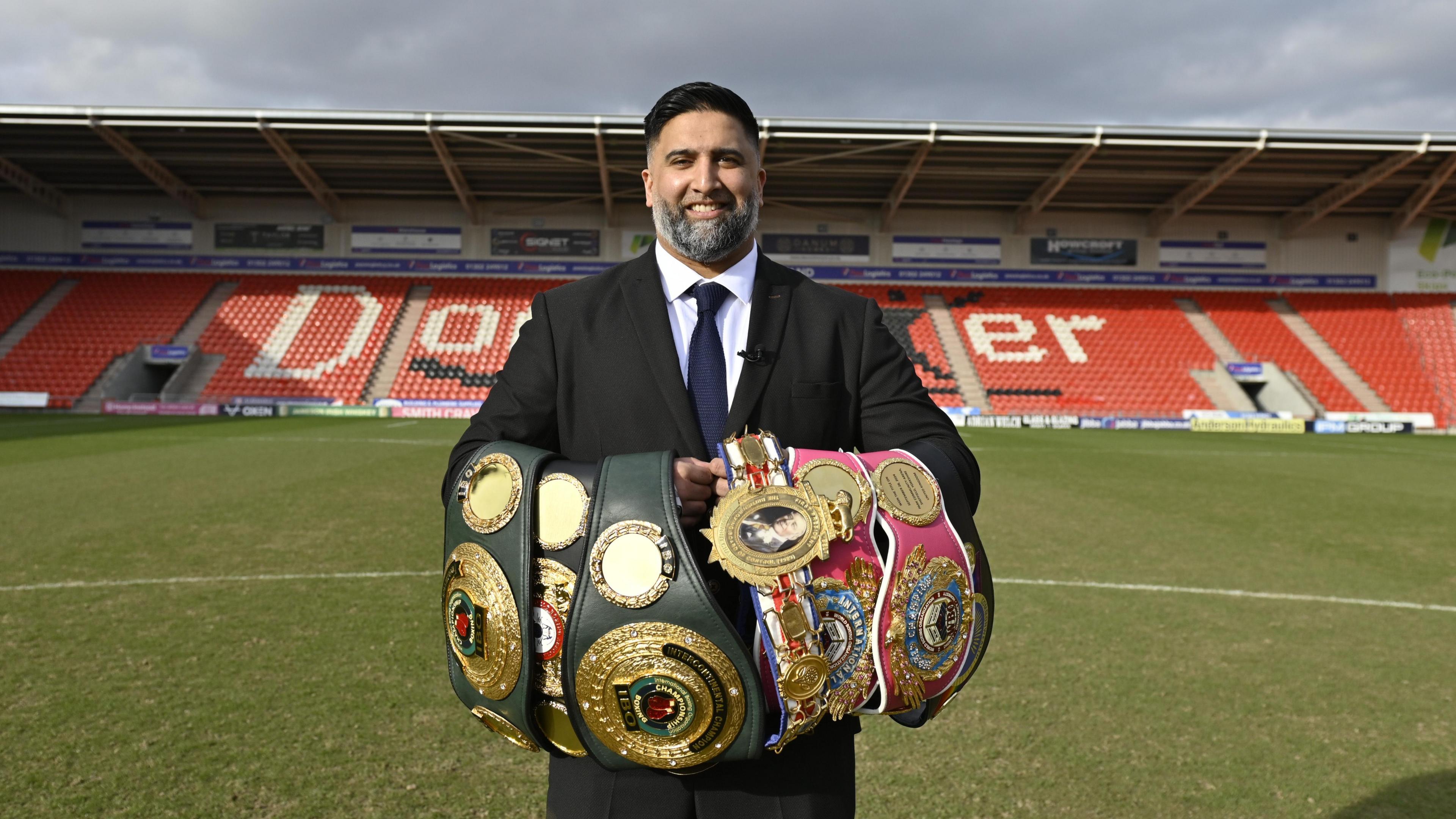Izzy Asif posing for cameras with Terri Harper's world titles