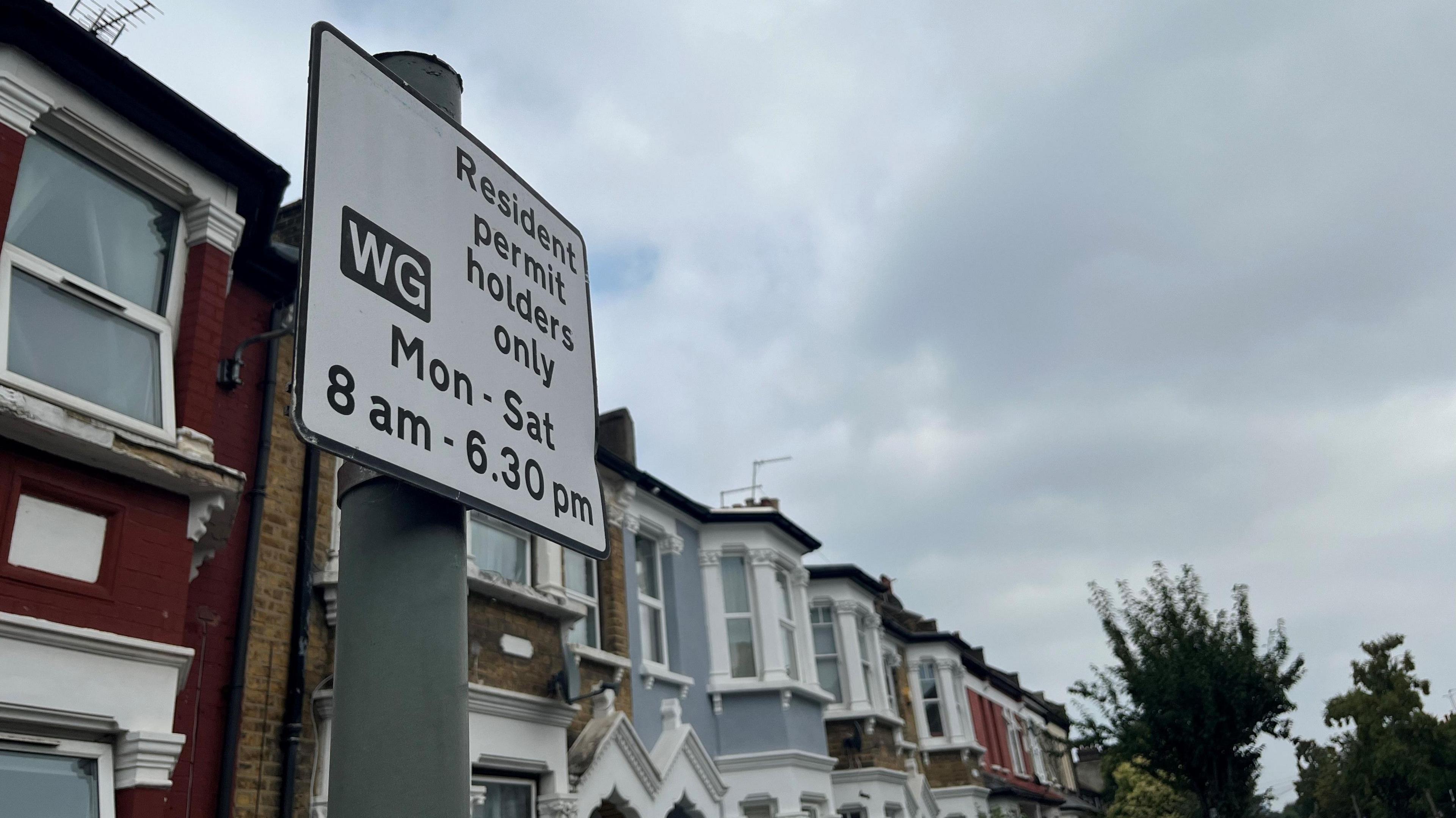 A parking restriction sign on a residential street