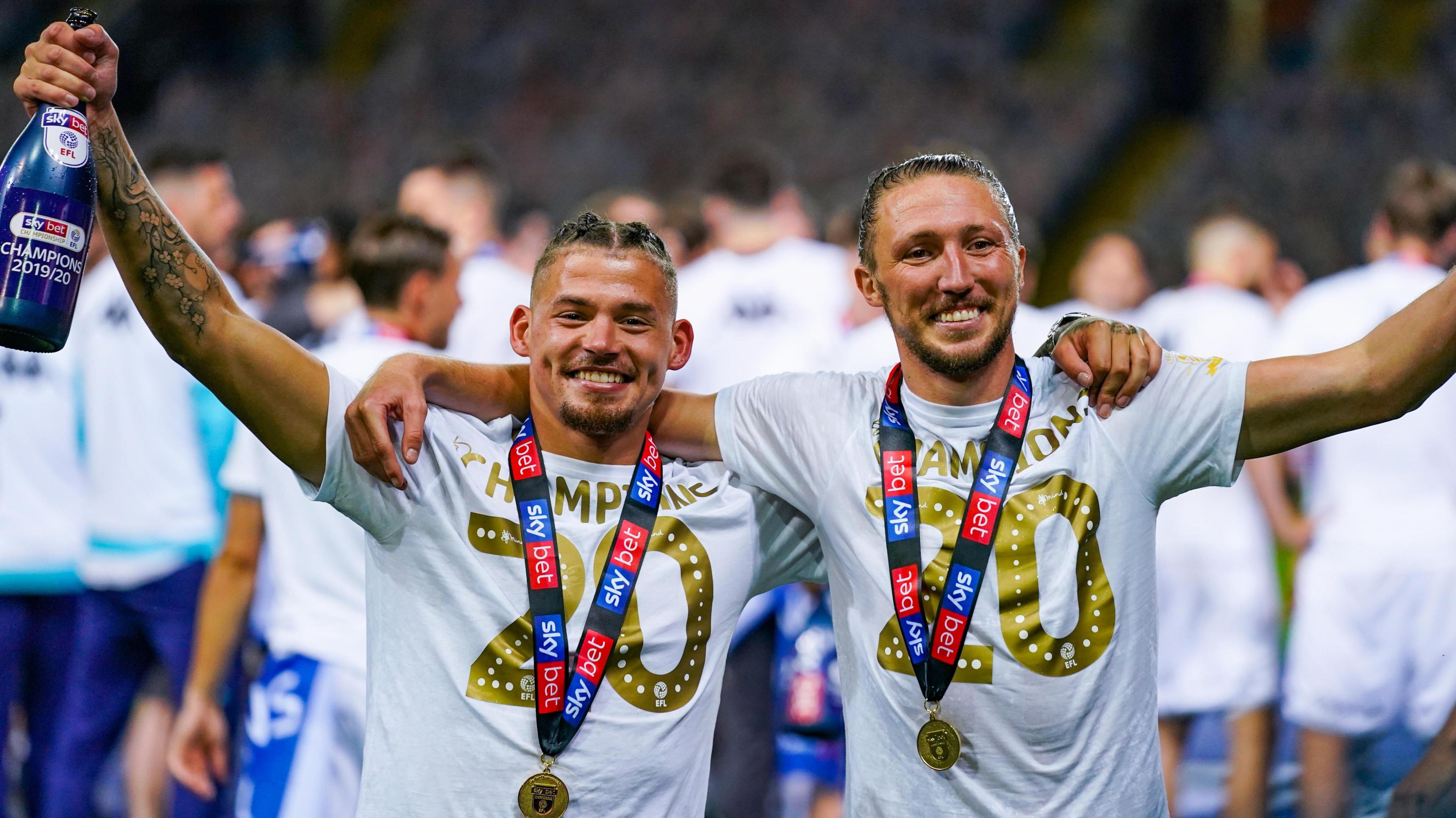 Kalvin Phillips (left) and Luke Ayling, wearing medals and special T-shirts, celebrate Leeds winning the Championship in 2020