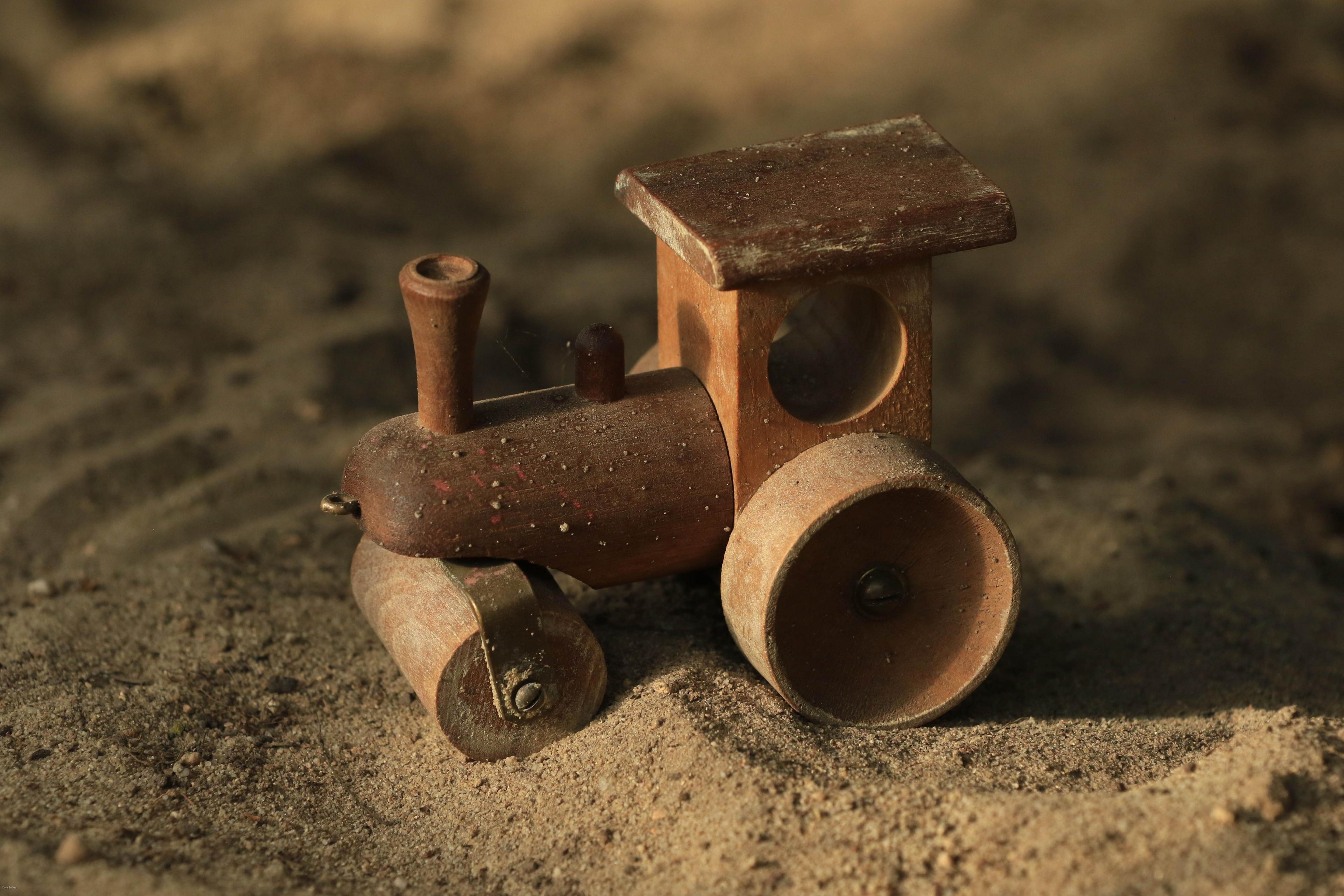 A wooden toy train on sand