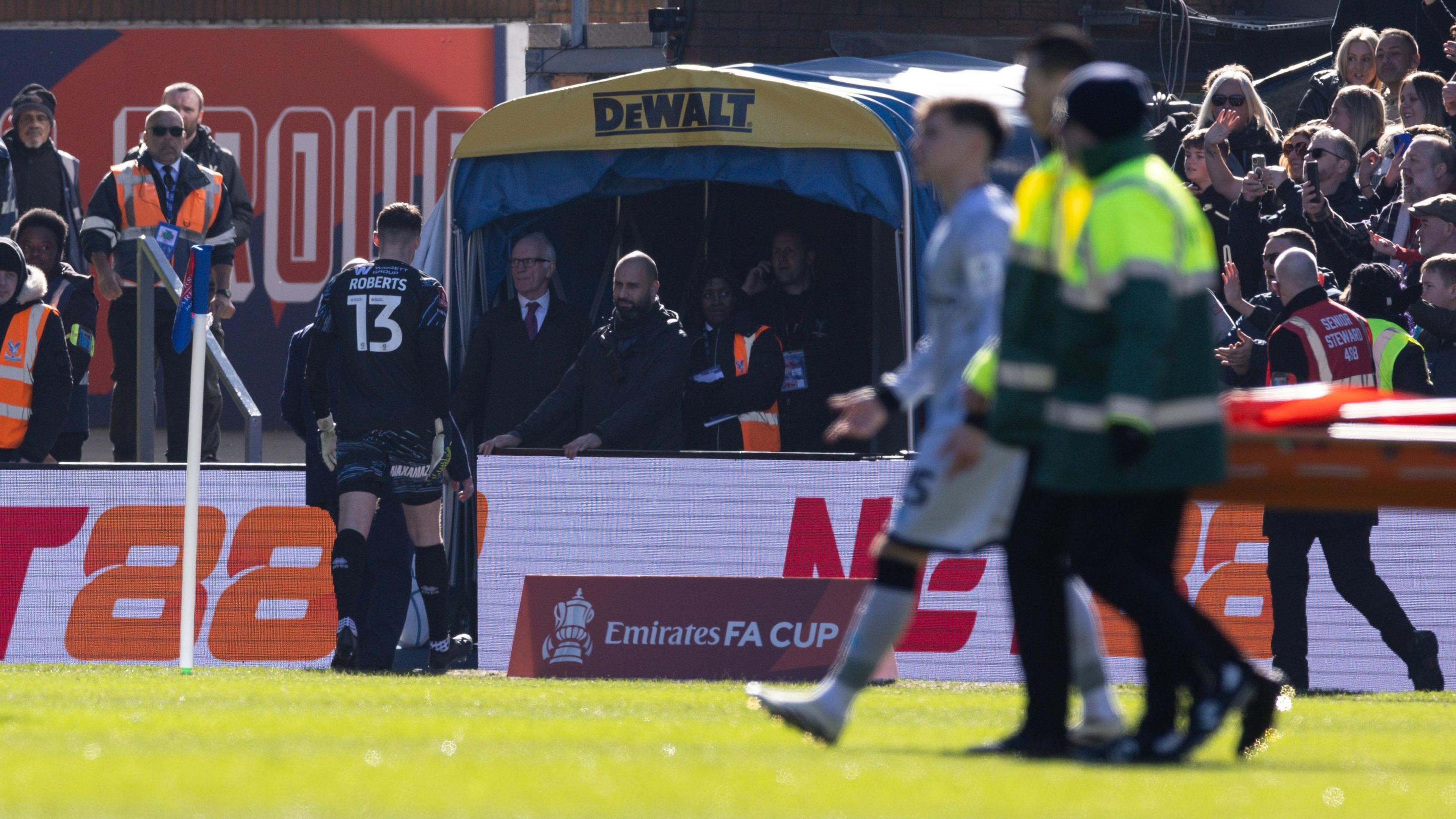 Liam Roberts heads down the tunnel as a stretcher comes on at Selhurst Park