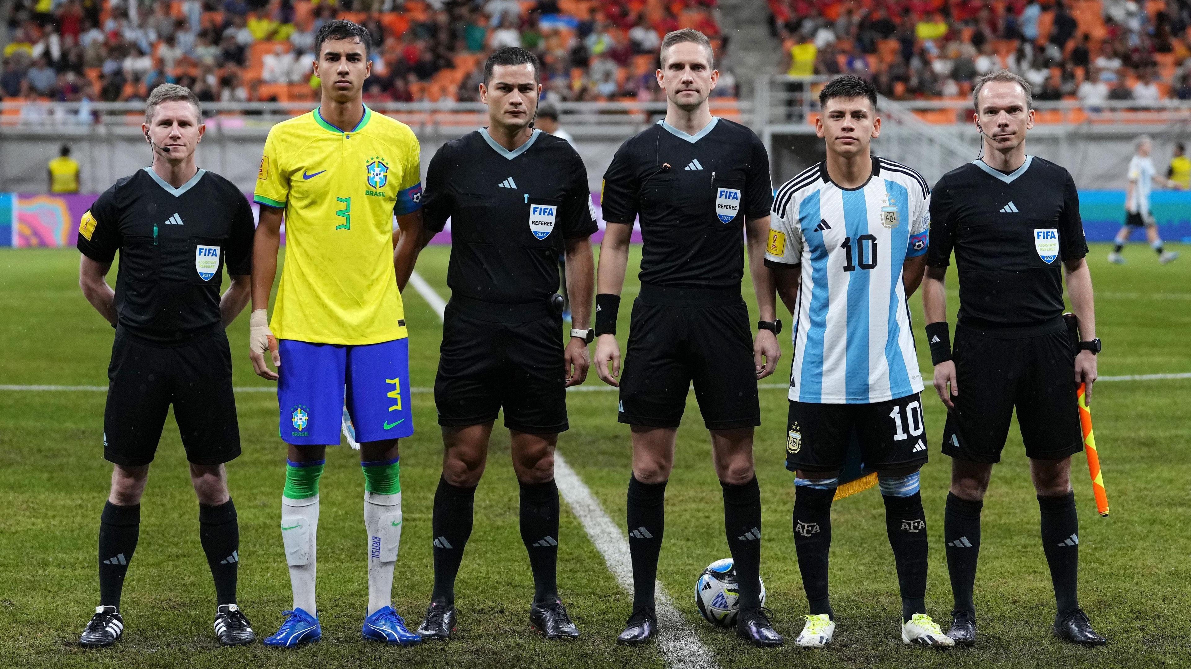 Assistant referee Isaak Bashevkin, Vitor Reis of Brazil, fourth official Keylor Herrera, match referee Espen Eskas, Claudio Echeverri of Argentina and assistant referee Jan Erik Engan pose for a photo prior to the FIFA U-17 World Cup Quarter Final match between Argentina and Brazil at Jakarta International Stadium