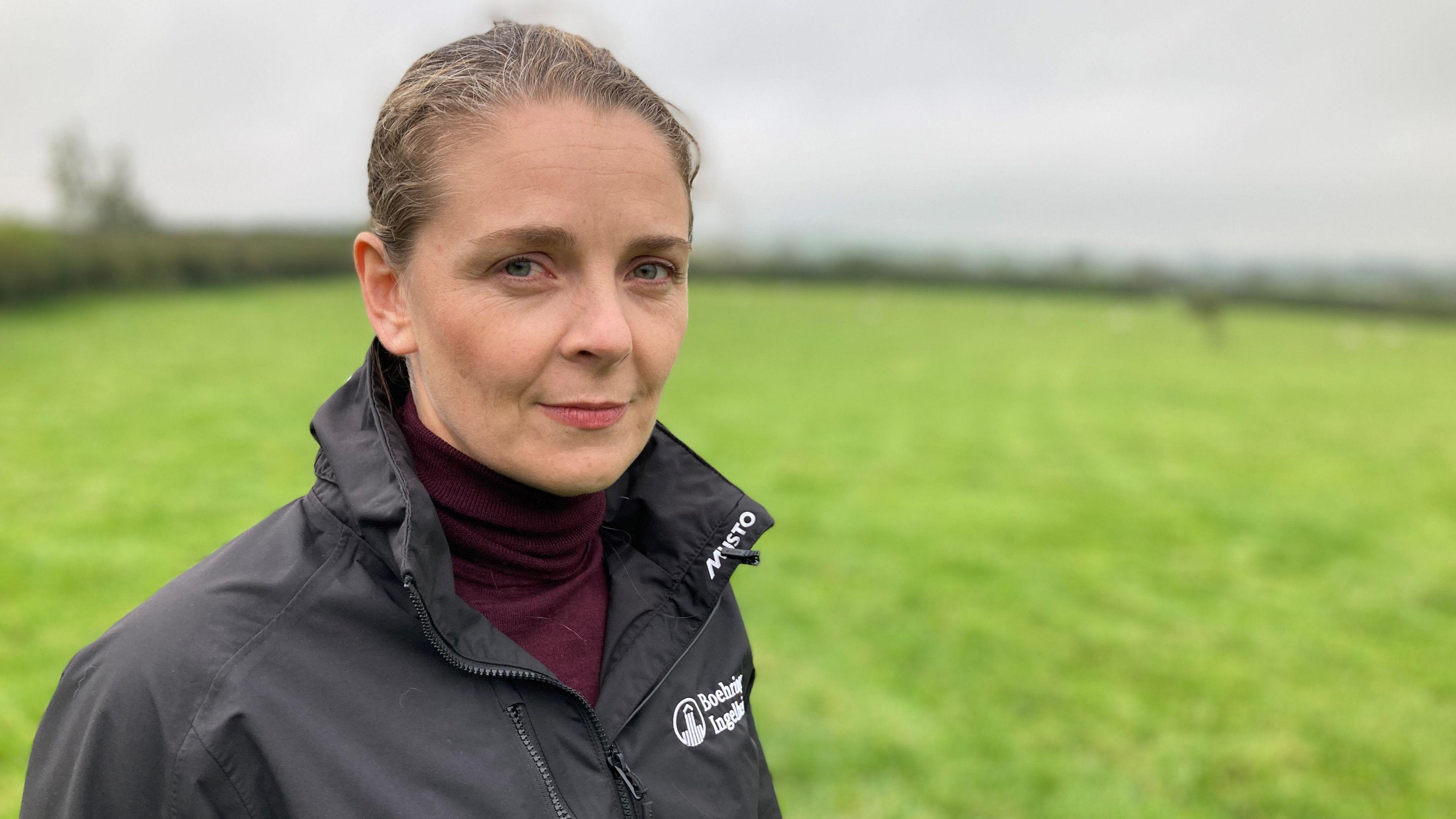 Dr Sioned Timothy of pharmaceutical firm Boehringer Ingelheim, in a field and looking at the camera