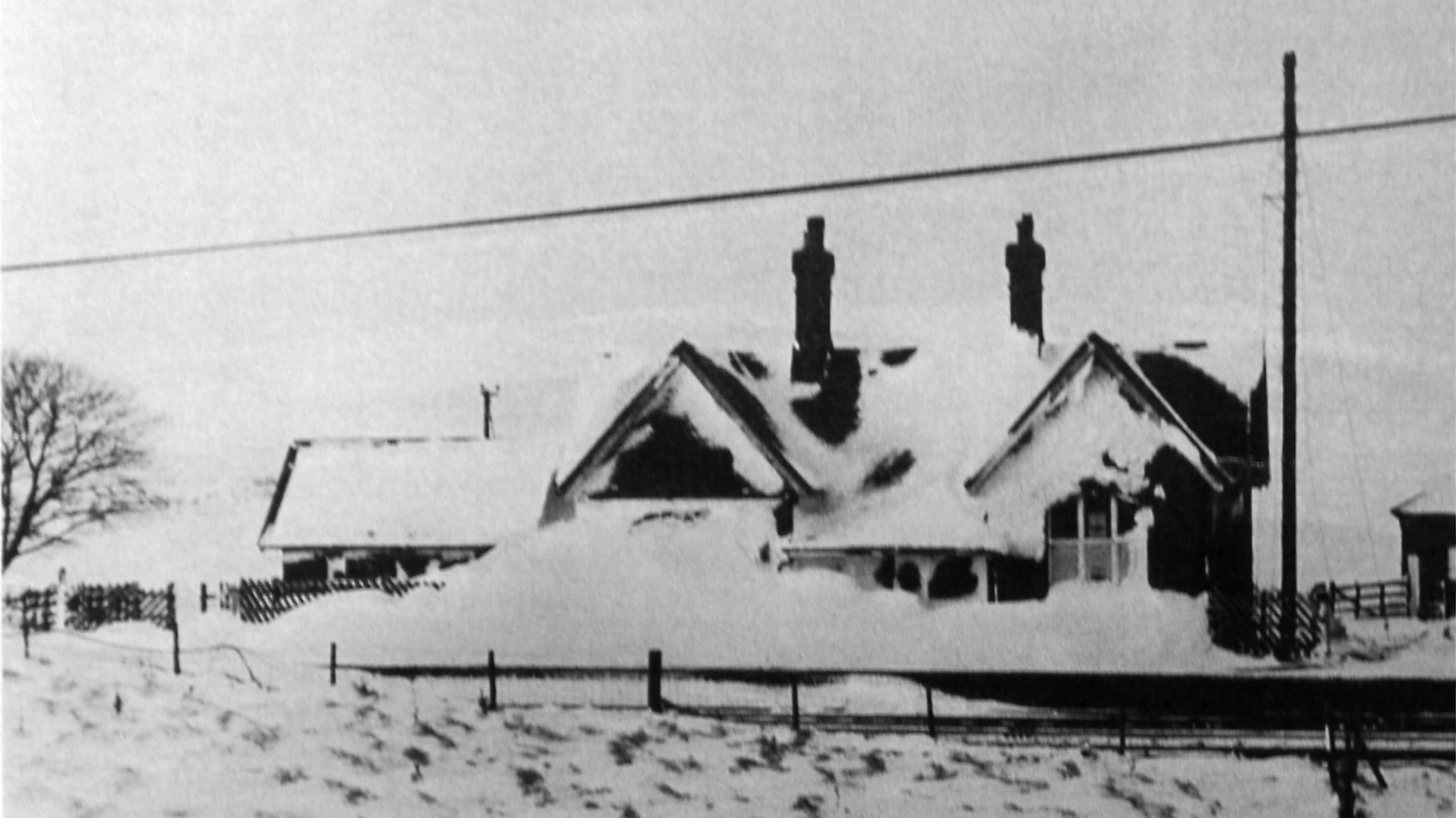A black and white image of a snow-covered station.