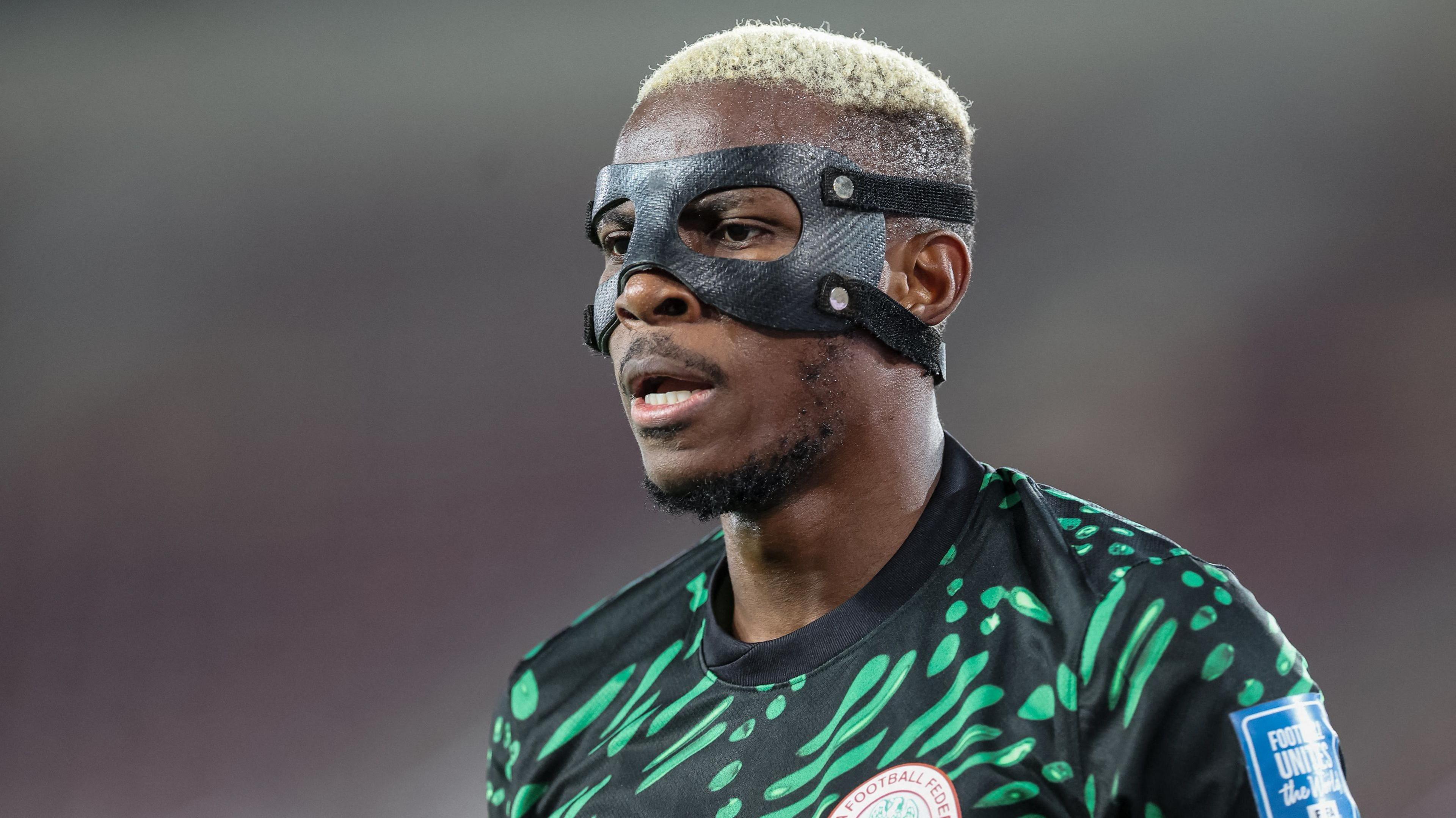 Victor Osimhen wearing a black protective face mask and a green and black Nigeria shirt