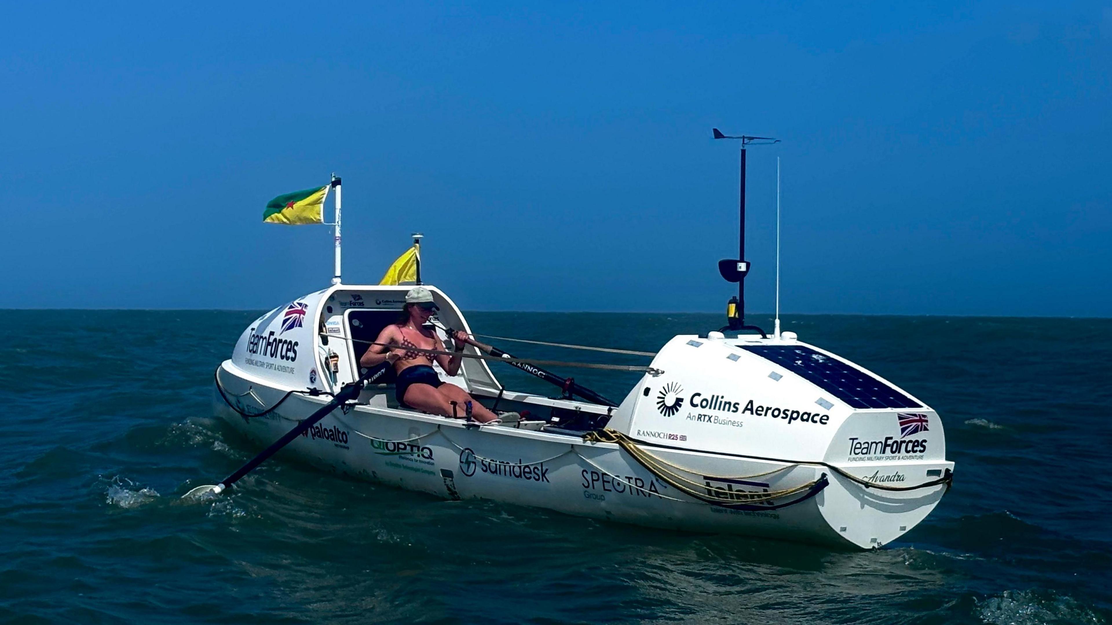 Zara rowing in a white rowing boat in the sea