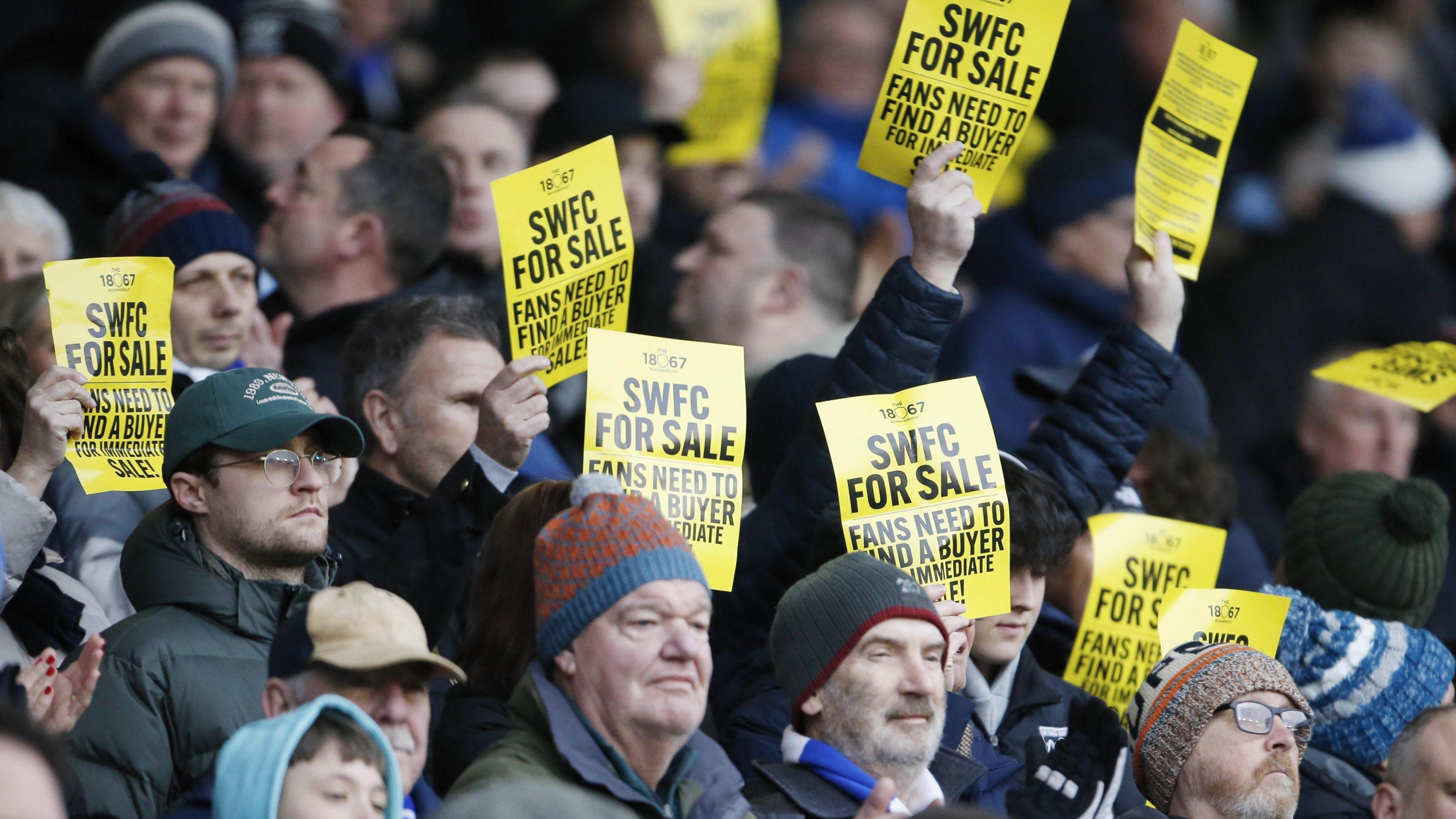Owls fans make their feelings known at a Championship game against Luton in February holding SWFC for sale banners
