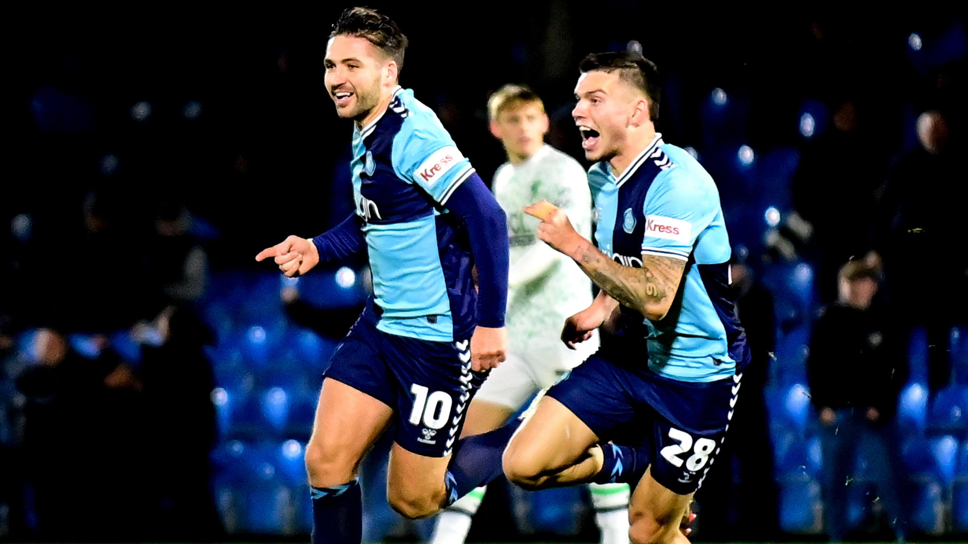 Luke Leahy is chased by Wycombe team-mate Aaron Morley as he sprints off in celebration