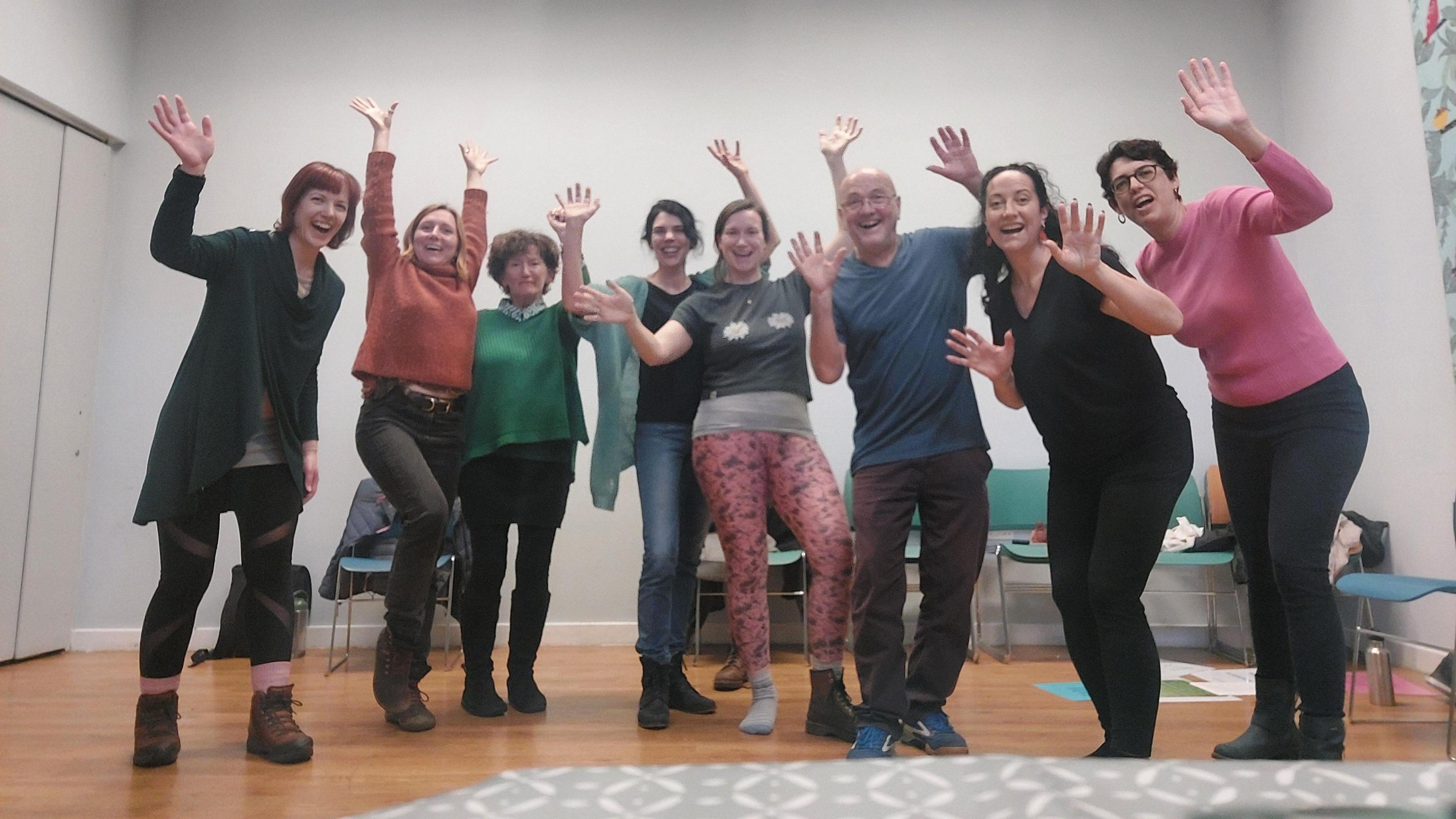 Seven women, alongside Joe Hoare, standing in a line with the hands in the air, smiling