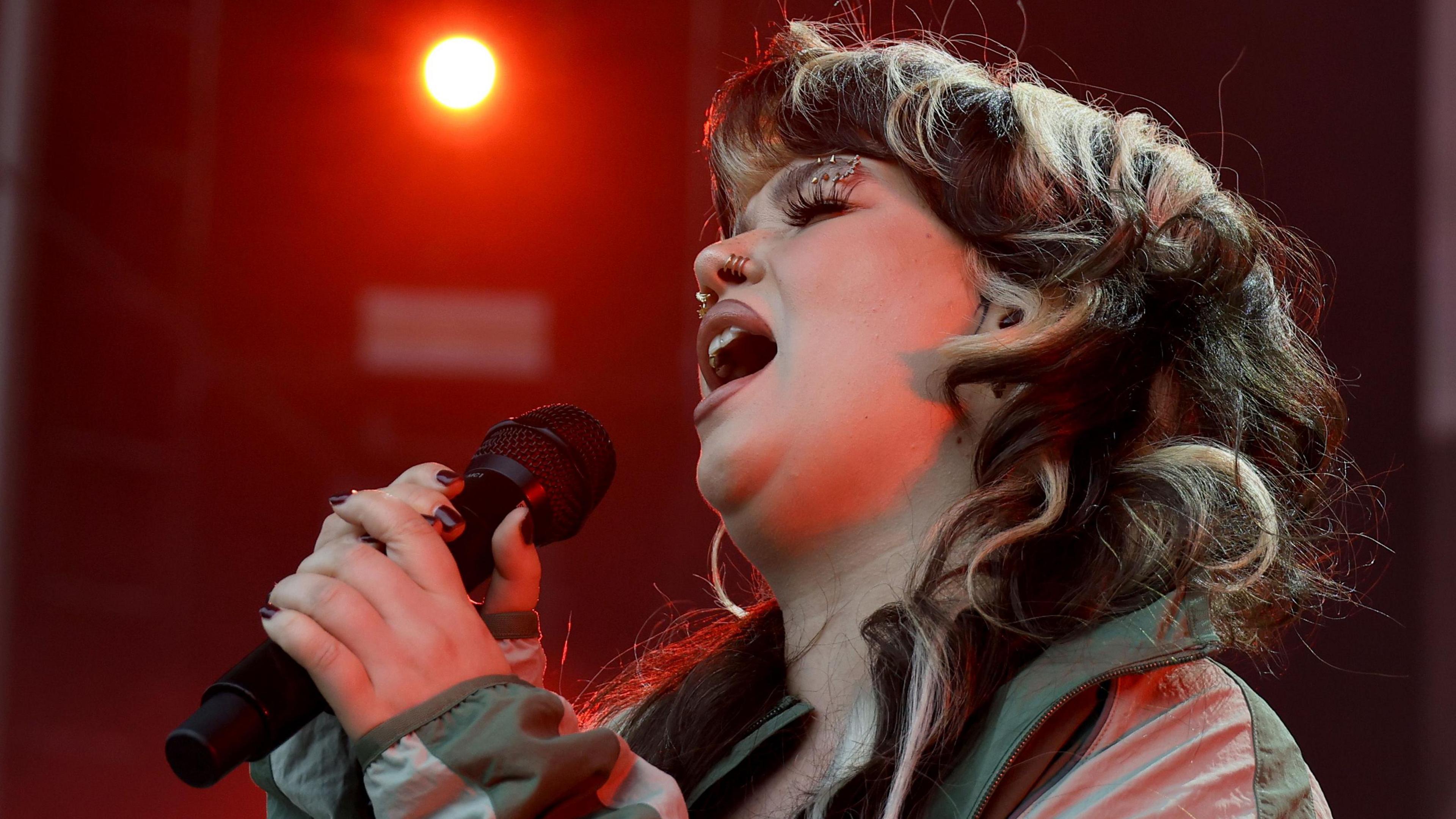 Lola Young singing on stage