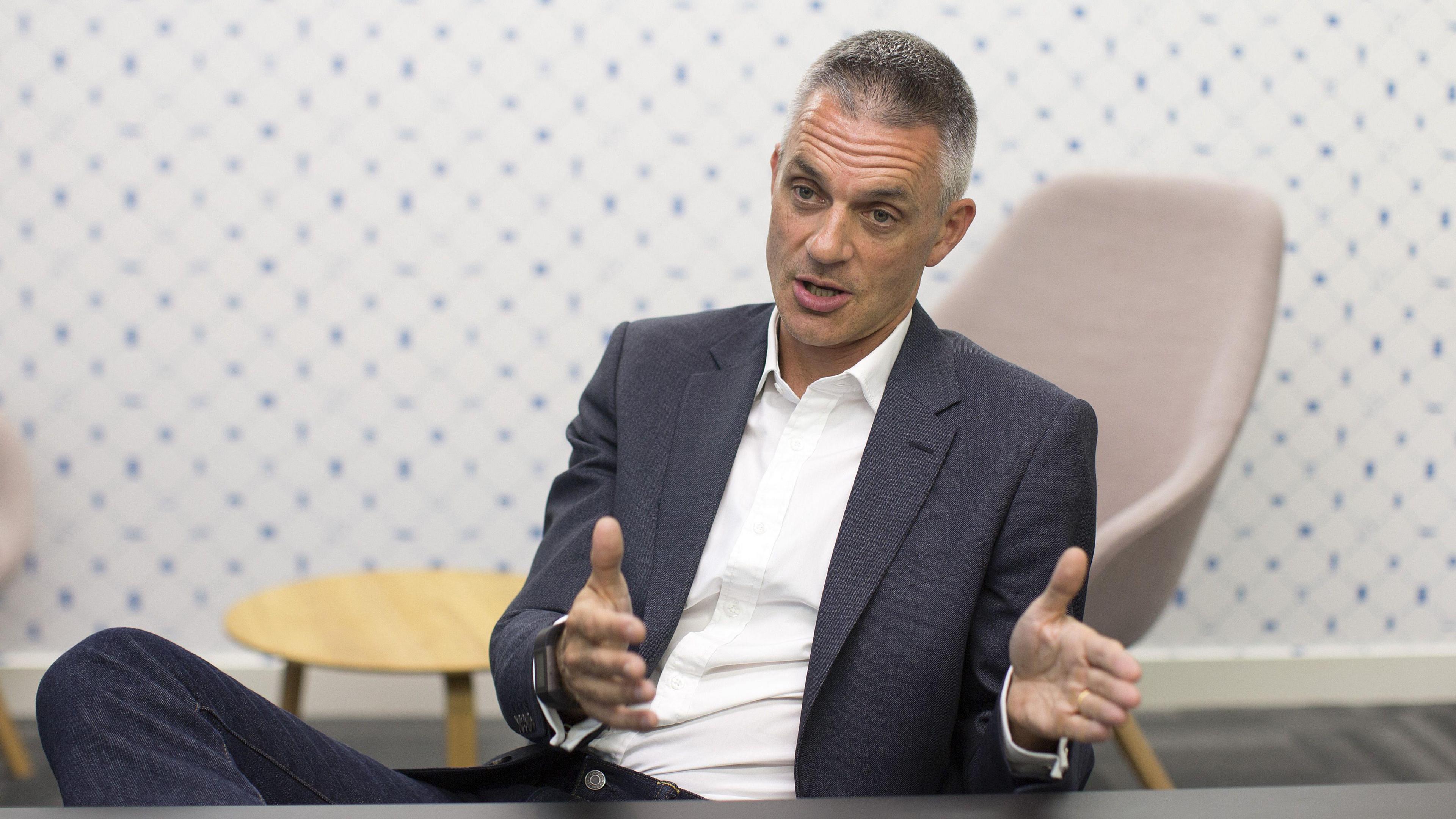 Tim Davie sitting in an armchair, gesturing with his hands