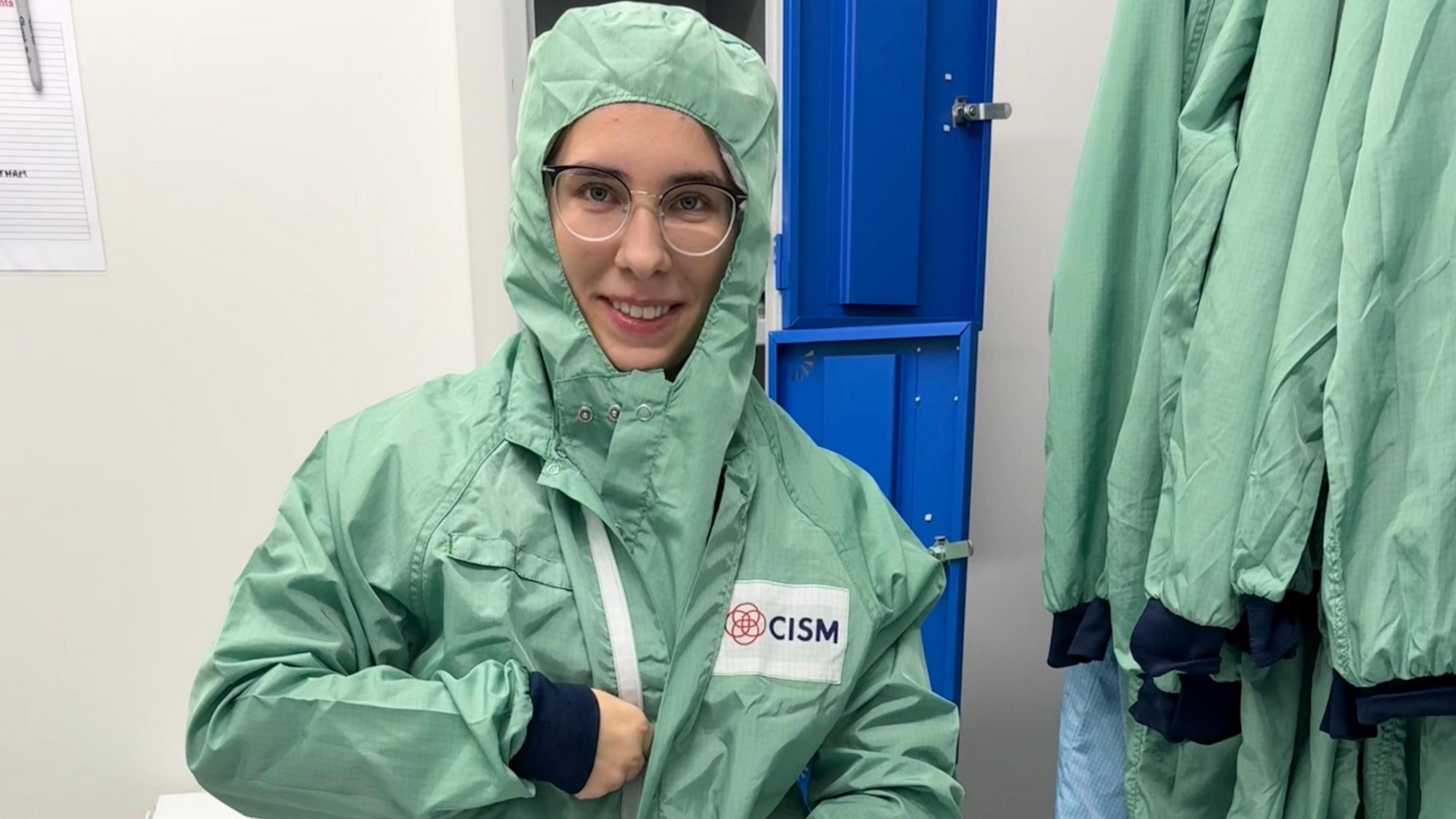 Kateryna mewn dillad amddiffynnol gwyrdd golau sydd hefyd yn gorchuddio'i gwallt