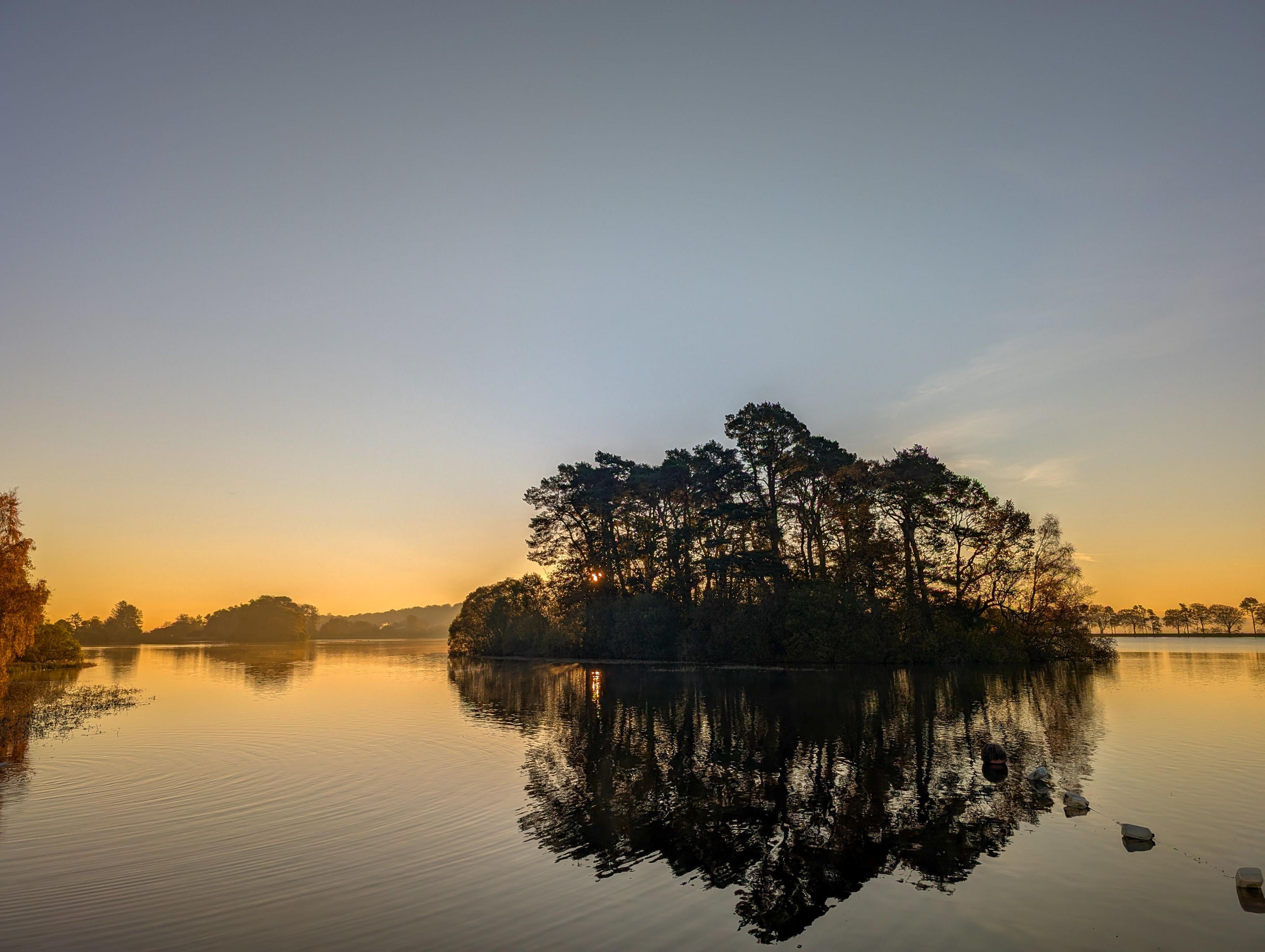 Morning sun shining over a country park on a misty morning