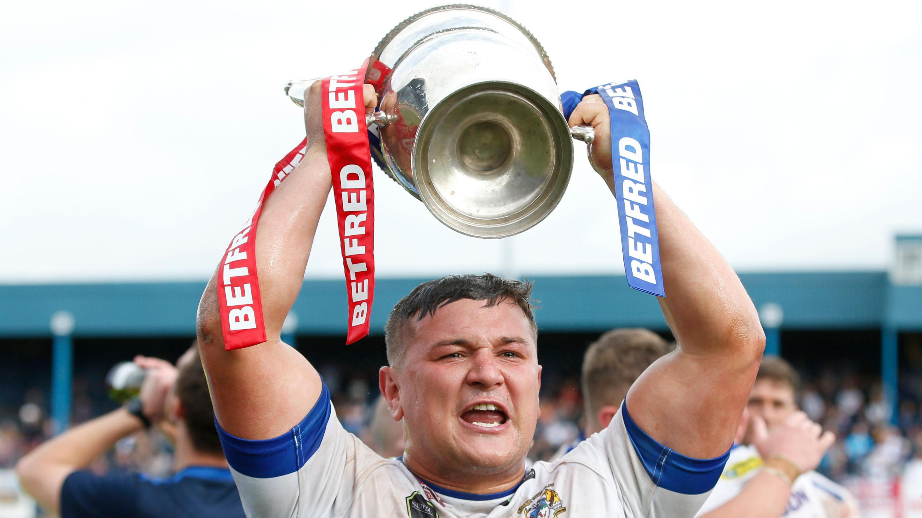 Jamie Doran lifting the trophy after Workington won the League 1 play-off final in 2021