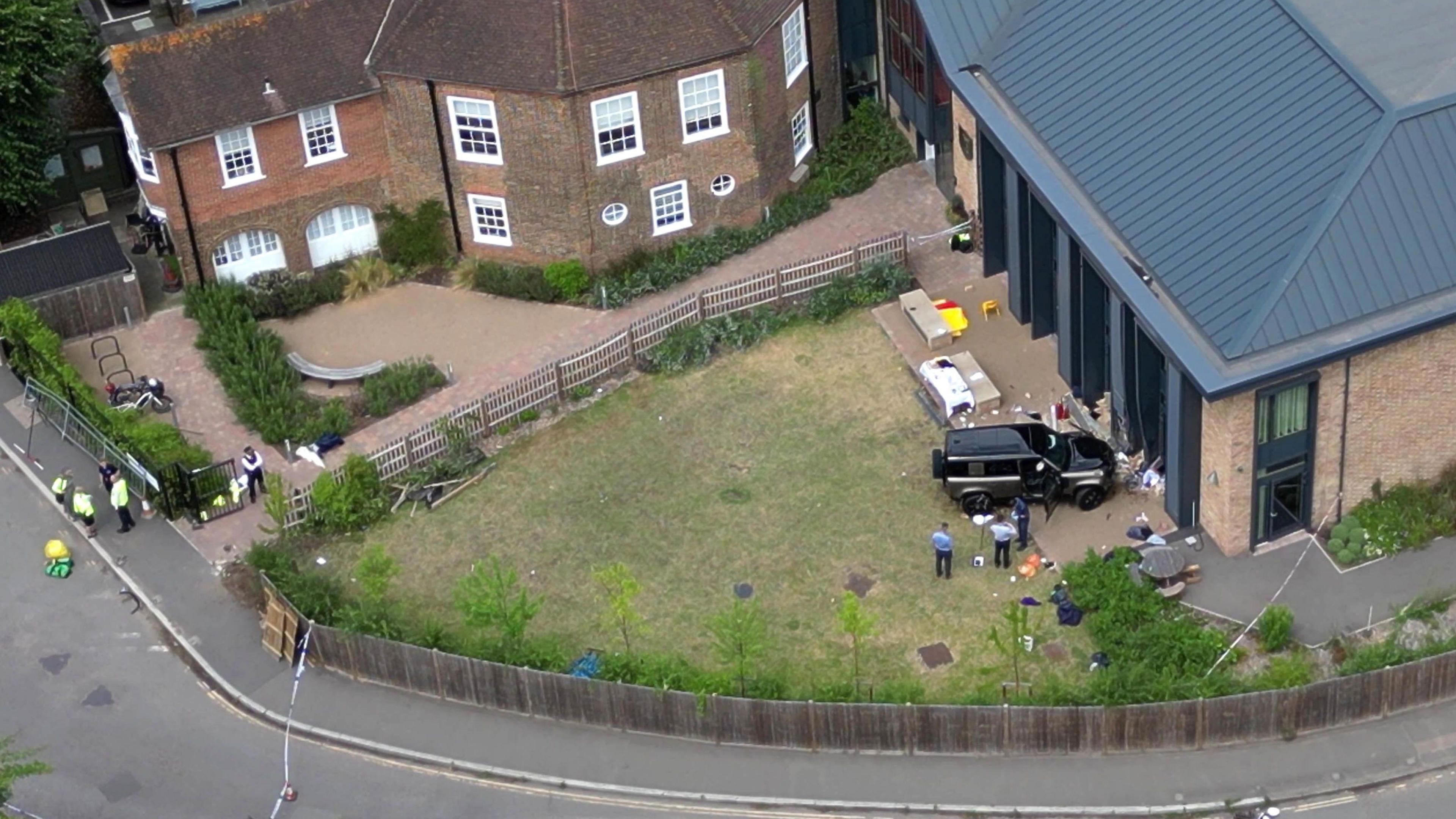 Aerial view of the scene of the black Land Rover crashed into the school playground with police and equipment strewn on the ground