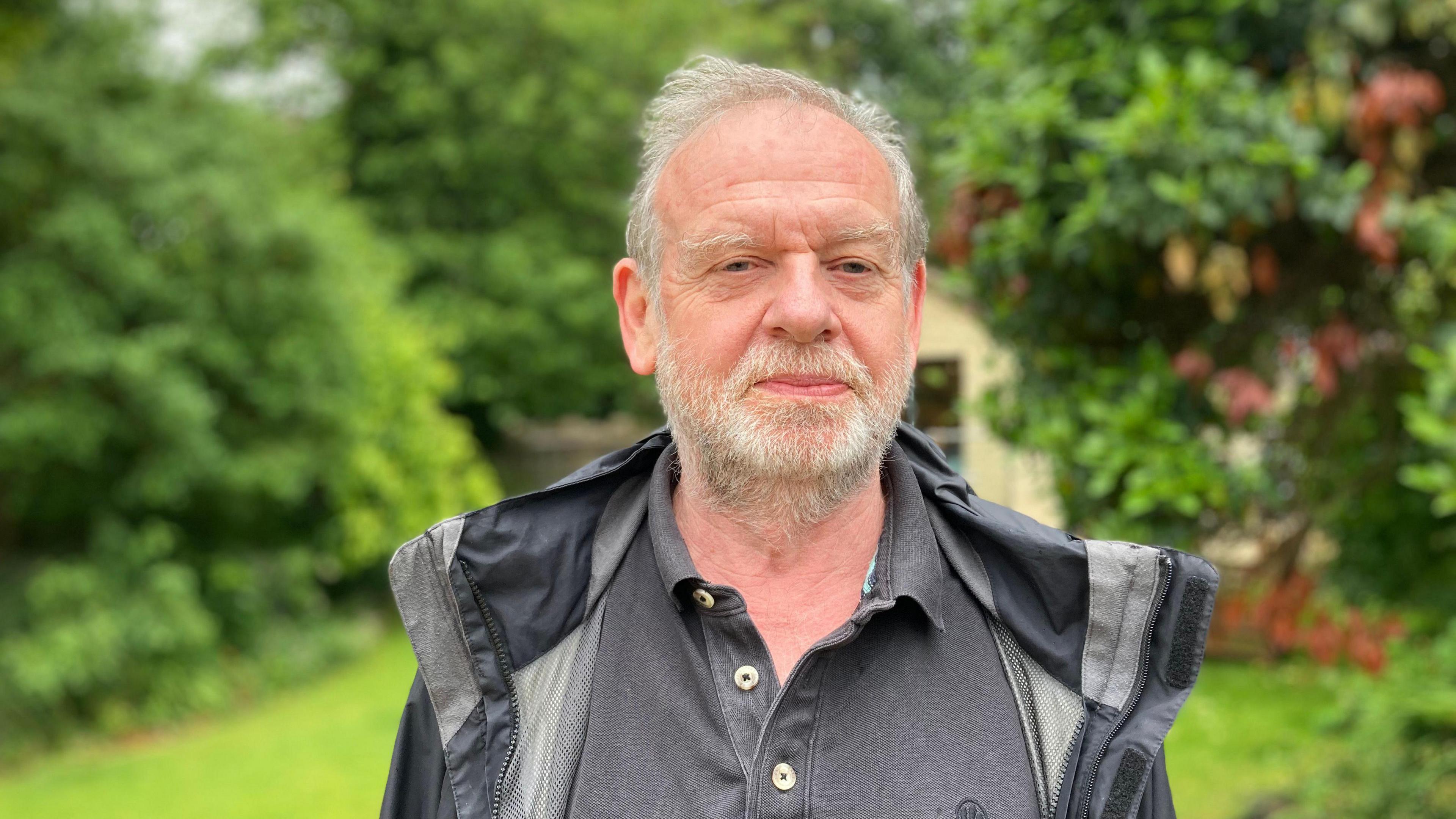 Tony McAleavy looks at the camera wearing  black rain jacket