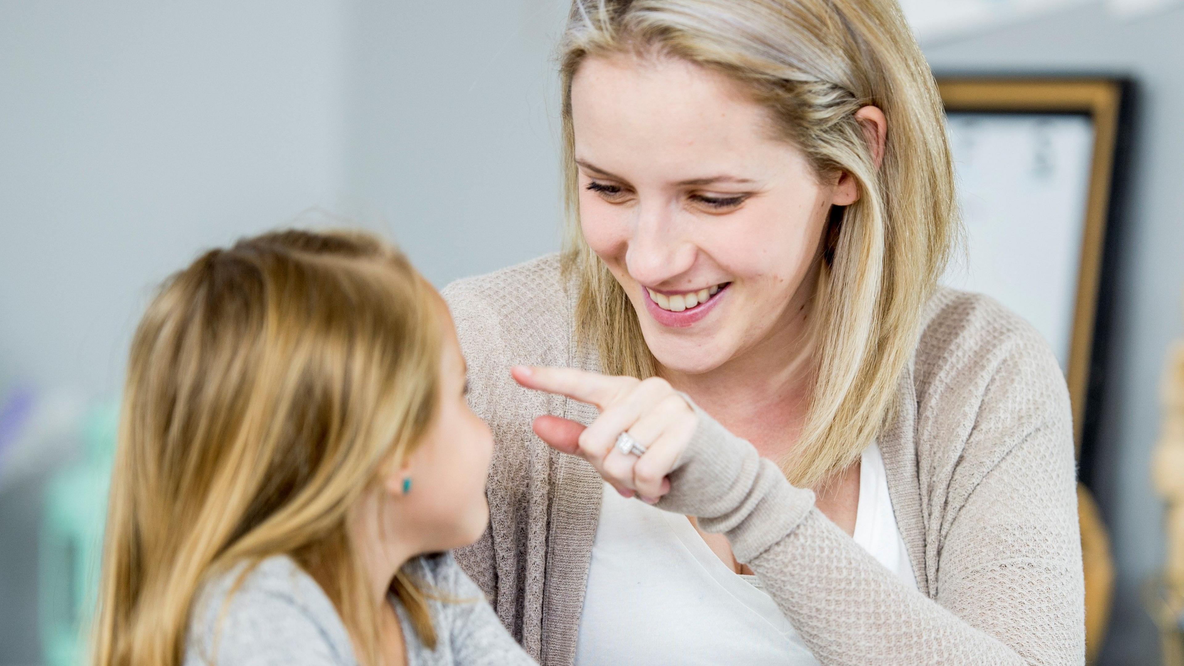 A woman 'boop's a child's nose