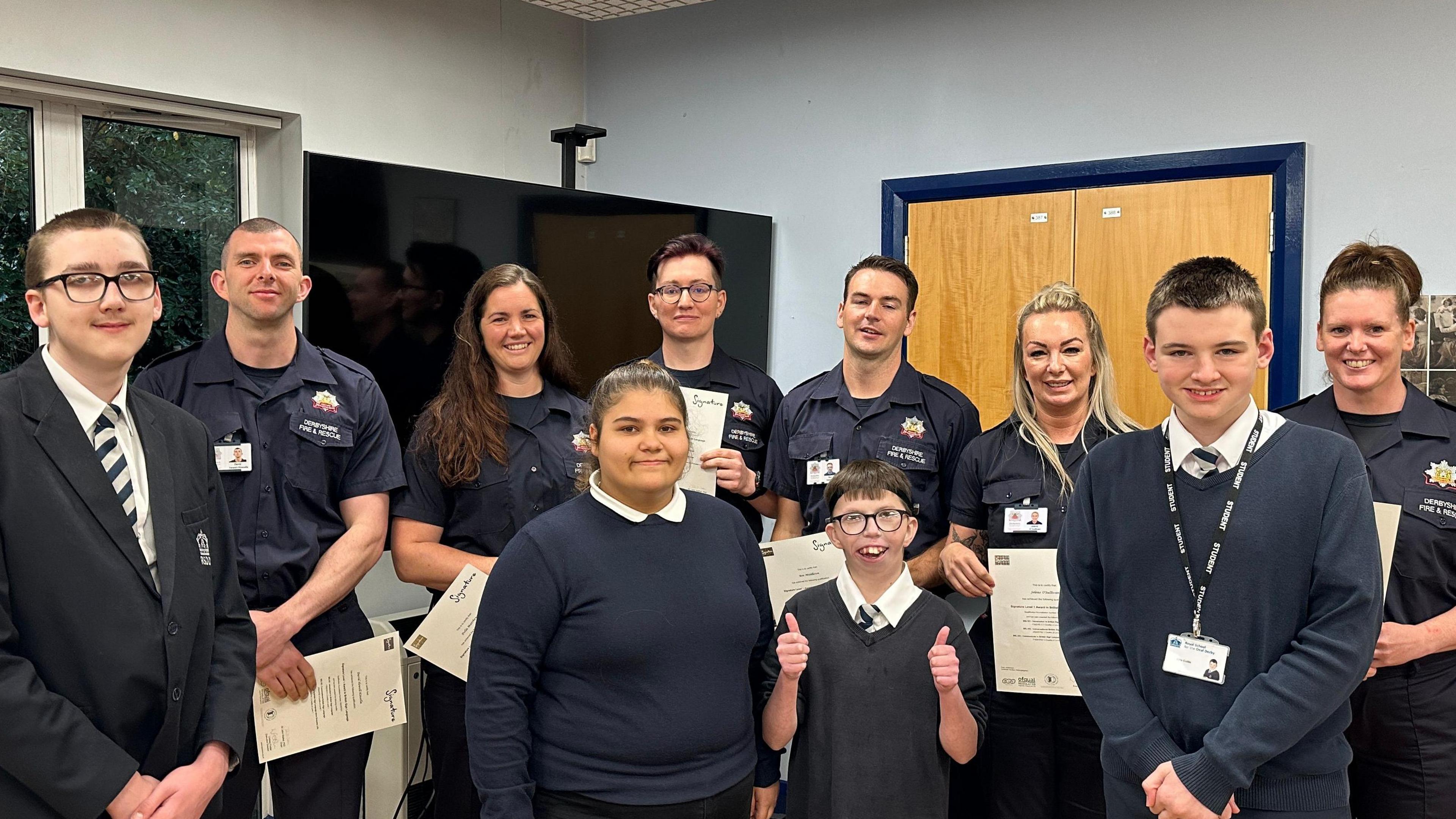 Children at the Royal School for the Deaf Derby presenting firefighters with their certificates