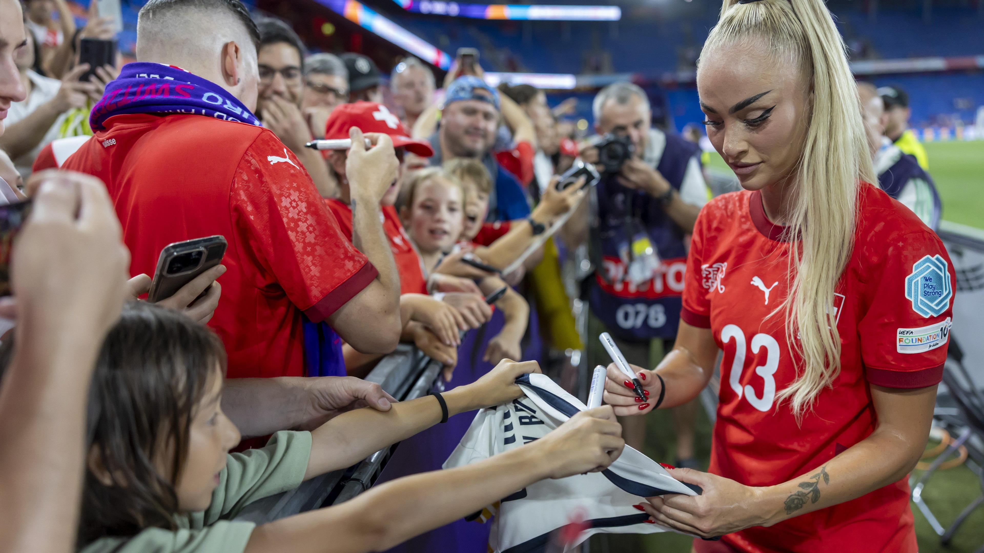 Switzerland's Alisha Lehmann signs autographs after the UEFA Women's EURO 2025 Group A soccer match between Switzerland and Norway at the St. Jakob-Park stadium in Basel, Switzerland,