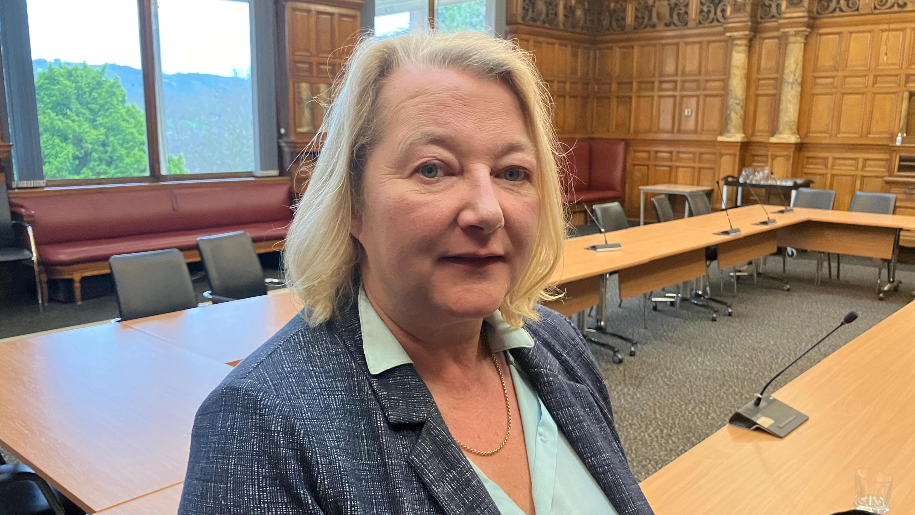 Picture of Councillor Carolyn Renwick. She has blonde hair and has a blue suit jacket on. She is inside the cabinet room inside County Hall in Matlock