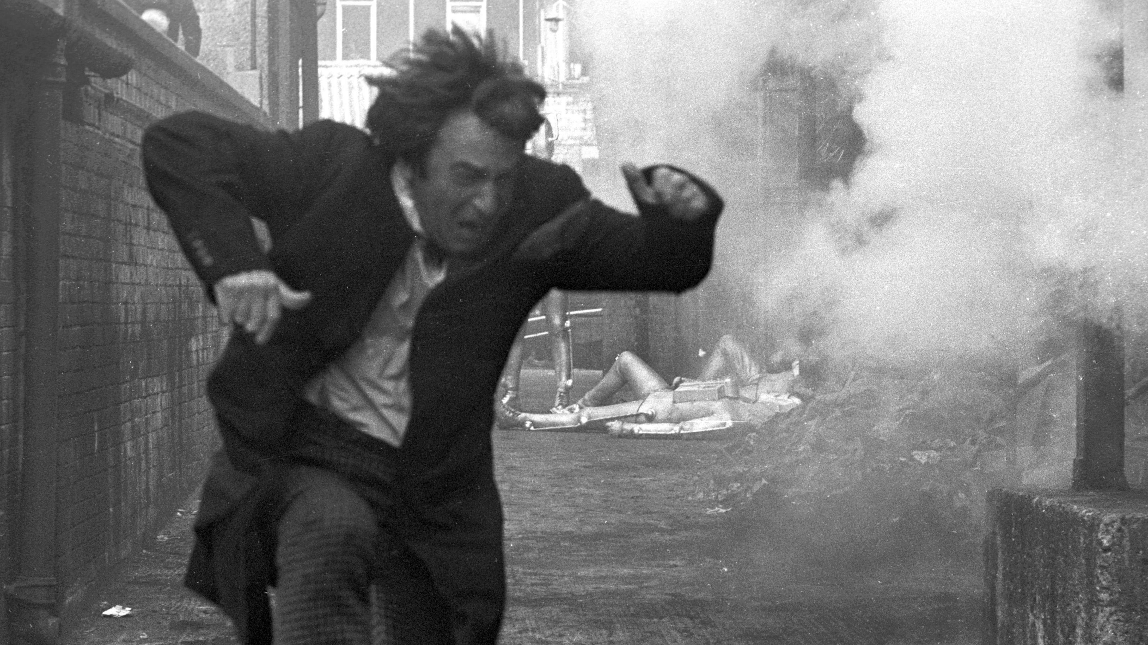 Patrick Troughton as the Doctor running through an explosion