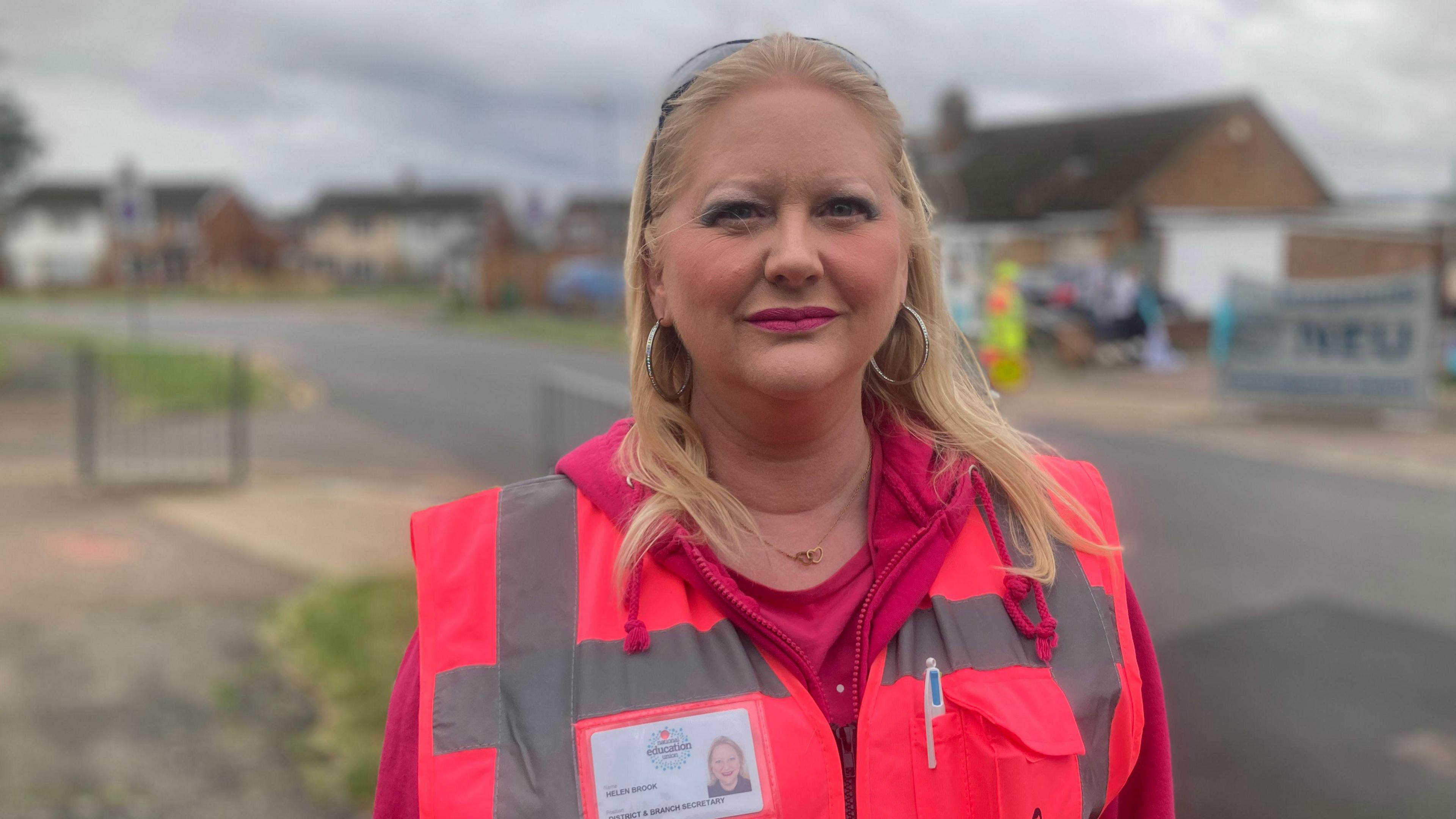 Woman standing outside a school wearing a hi-vis jacket