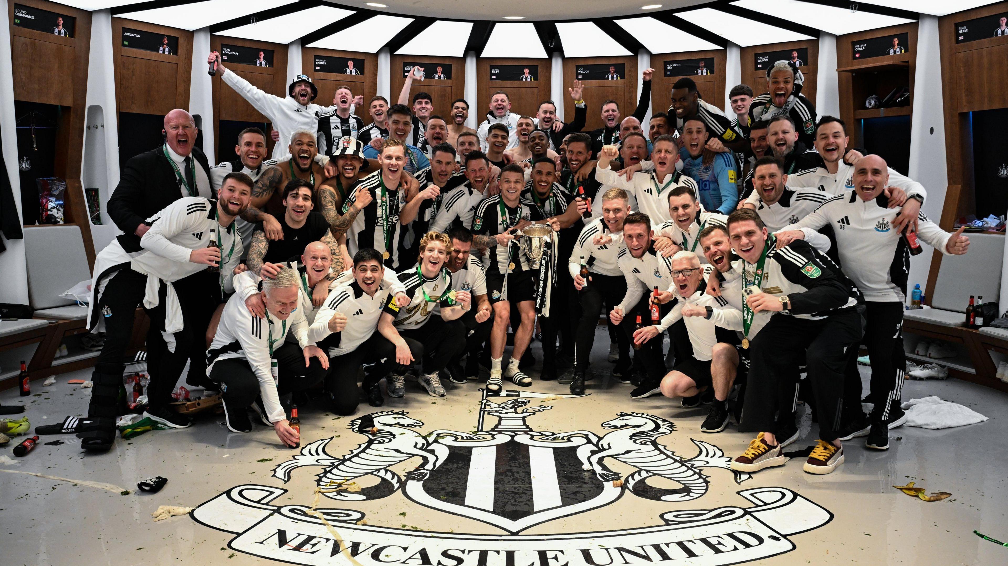 Newcastle players and staff celebrate EFL cup victory in the changing room at Wembley