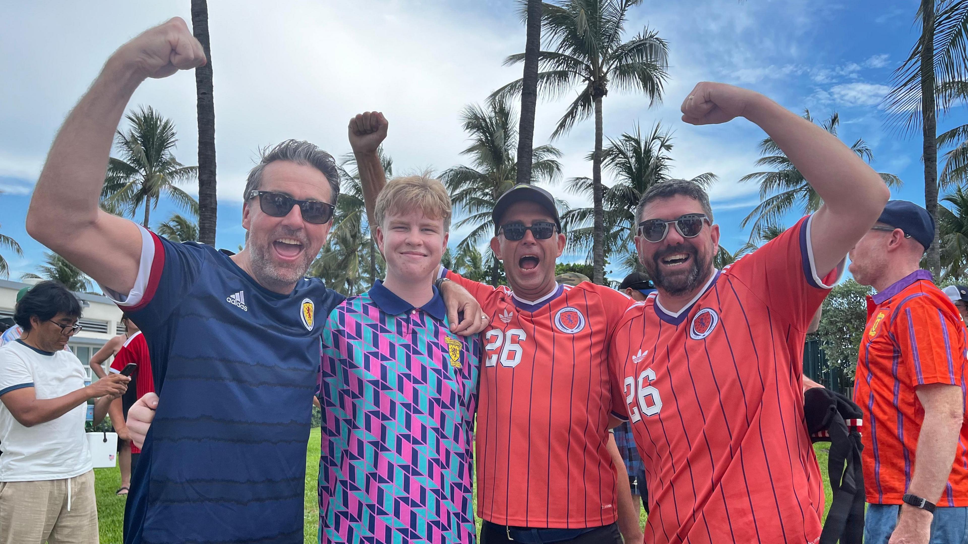 A group of men with their hands in the air wearing Scotland tops