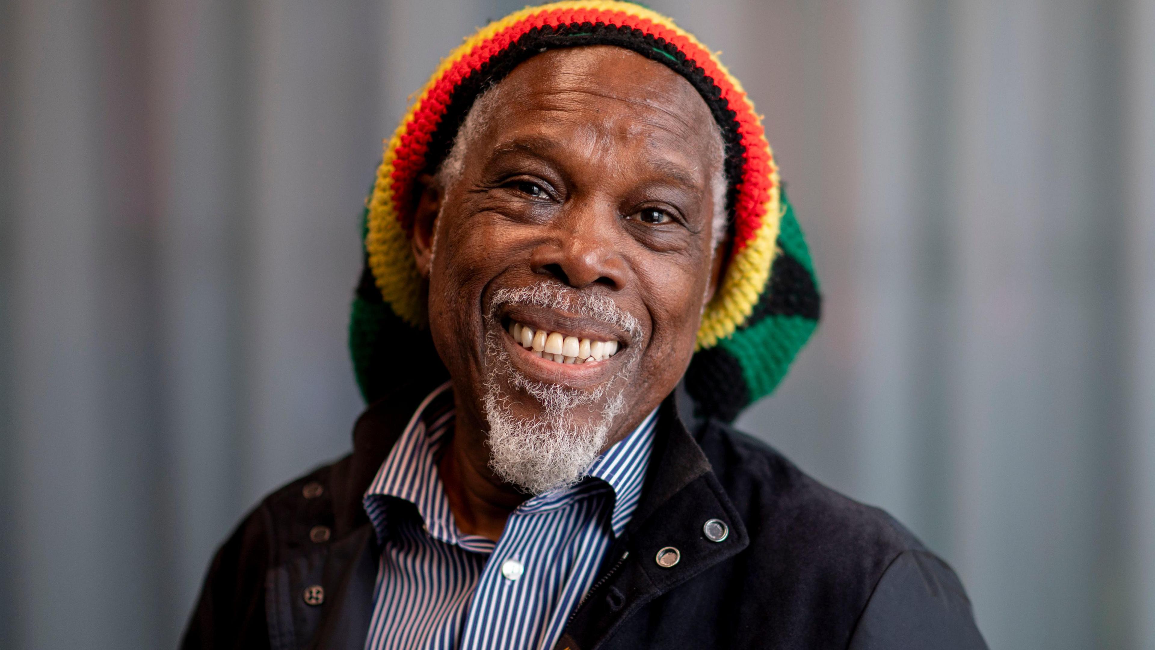 Billy Ocean, wearing a blue and white striped t-shirt a dark jacket and a Rastafarian hat on
