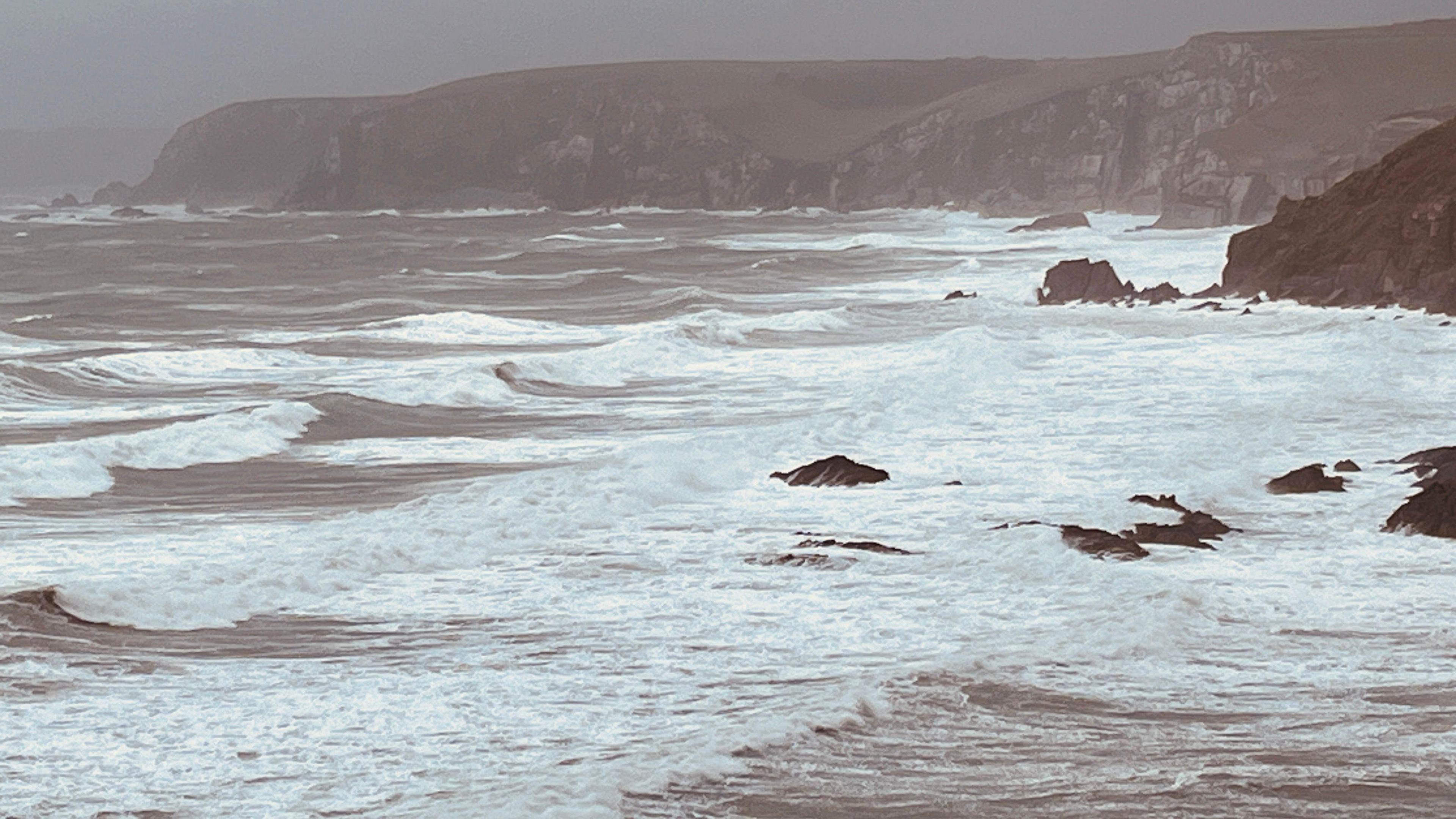 Bigbury sea during Storm Bert in 2024. The waves are choppy and there are rocks in the distance.