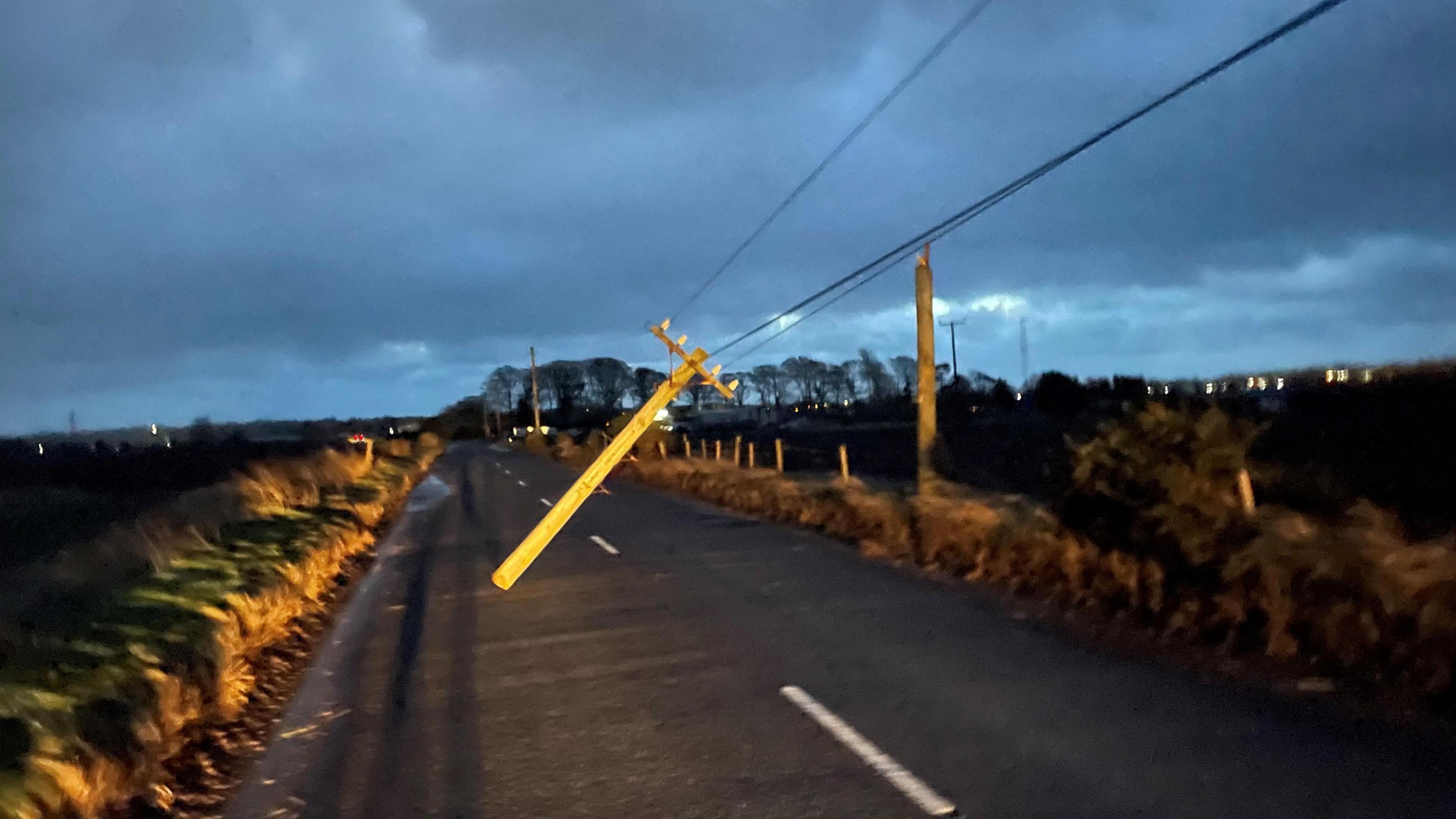 A telegraph pole hanging by electric lines across Blaris Road in County Antrim 