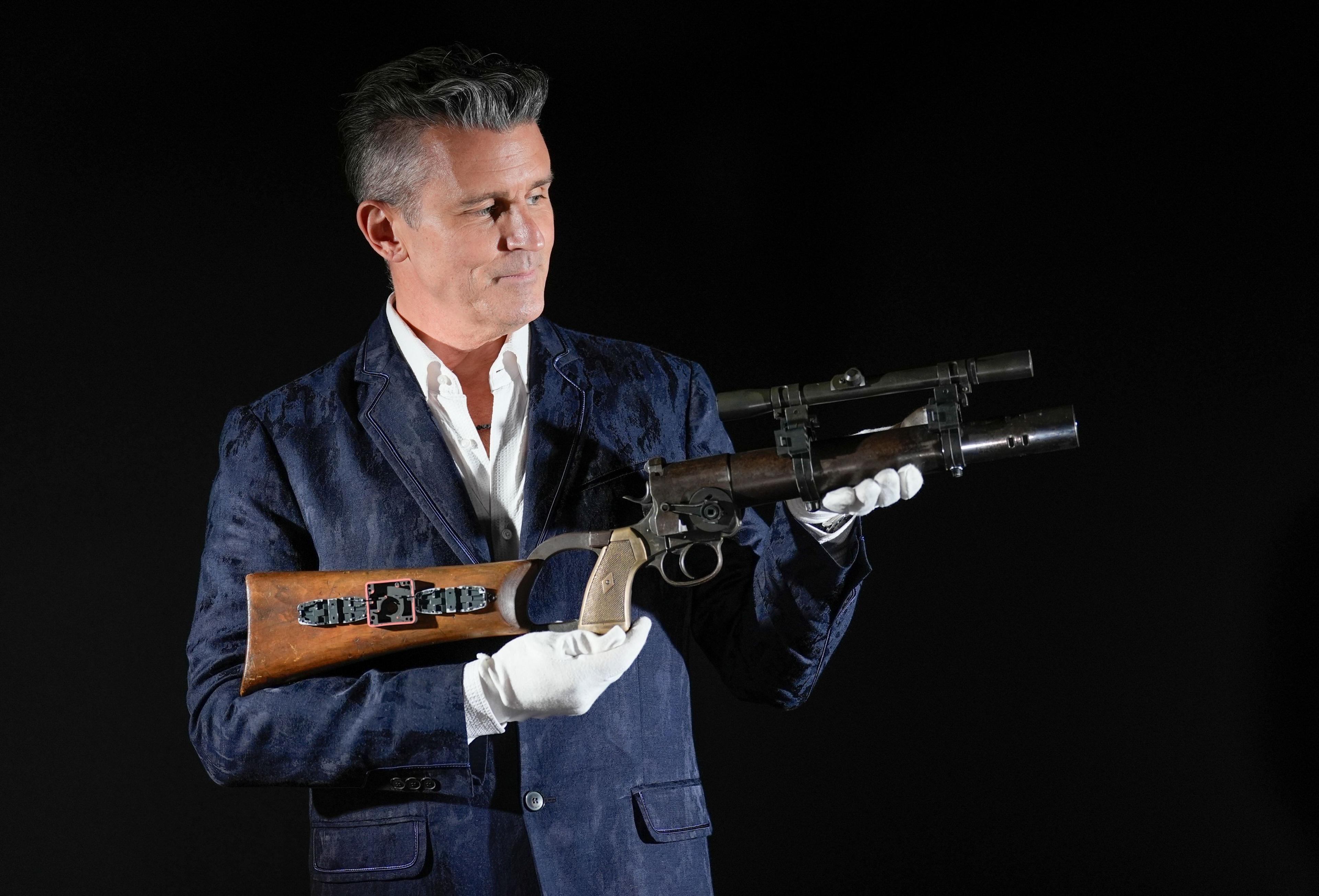 Propstore CEO Stephen Lane holds Boba Fett's (Jeremy Bulloch) Hero screen, photo, and serial number-matched EE-3 Carbine Rifle from the 1980 film 'Star Wars: The Empire Strikes Back' (estimate £350,000 - 700,000) during a photo call.
