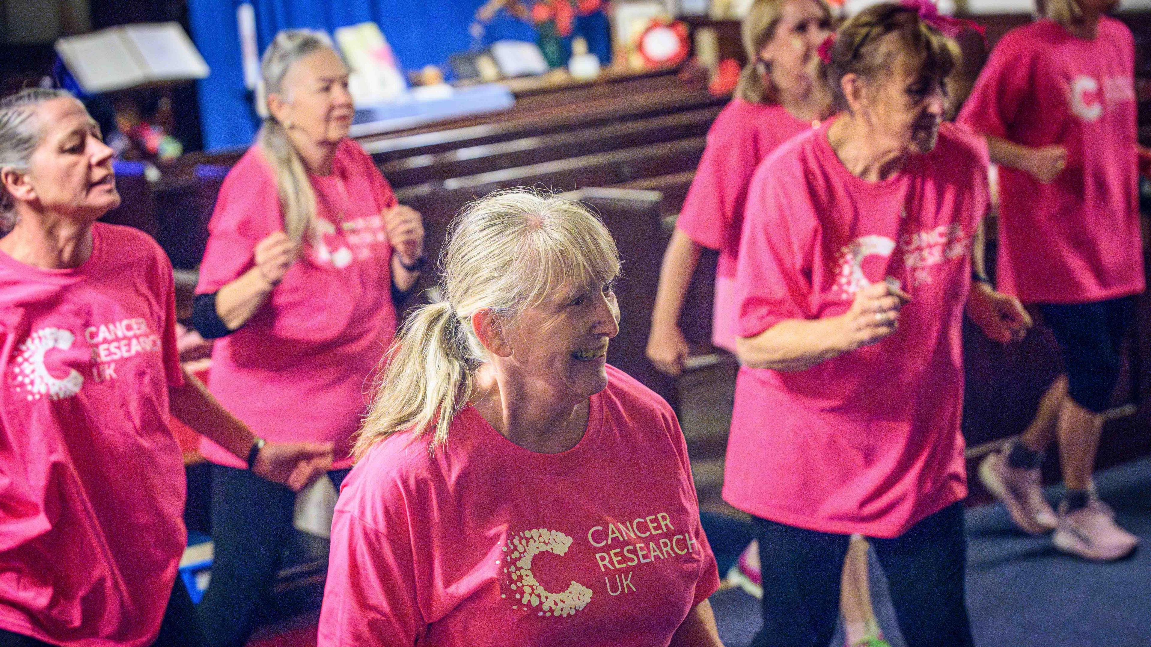 Women in pink t-shirts dance in the zumbathon