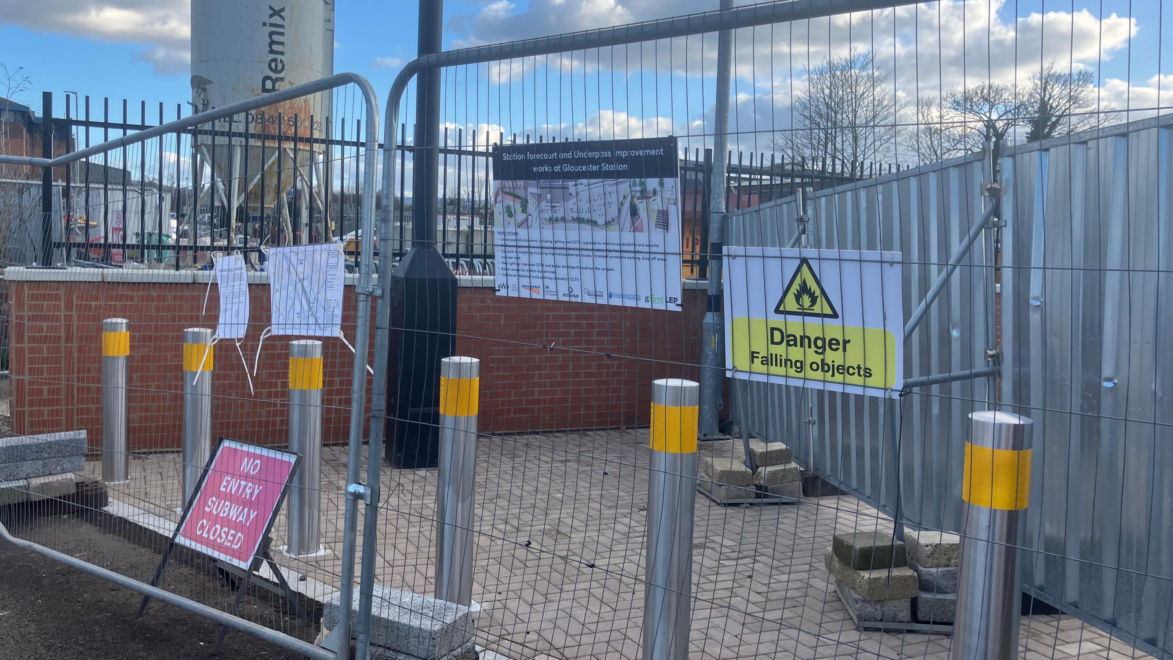 Metal barricades and signage on a construction site, where a subway has been upgraded and refreshed