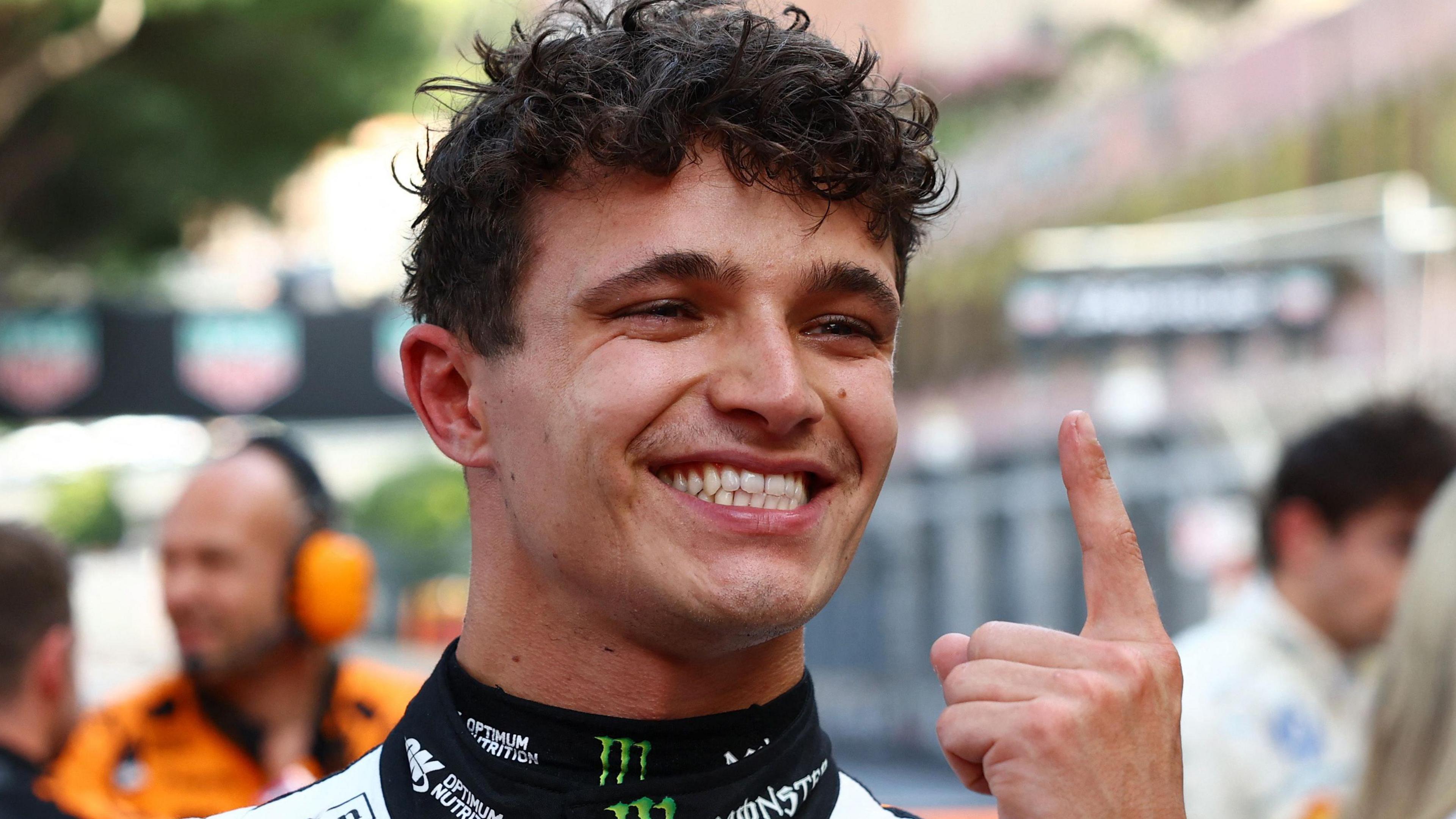 Lando Norris holds up his index finger in celebration after winning the Monaco Grand Prix