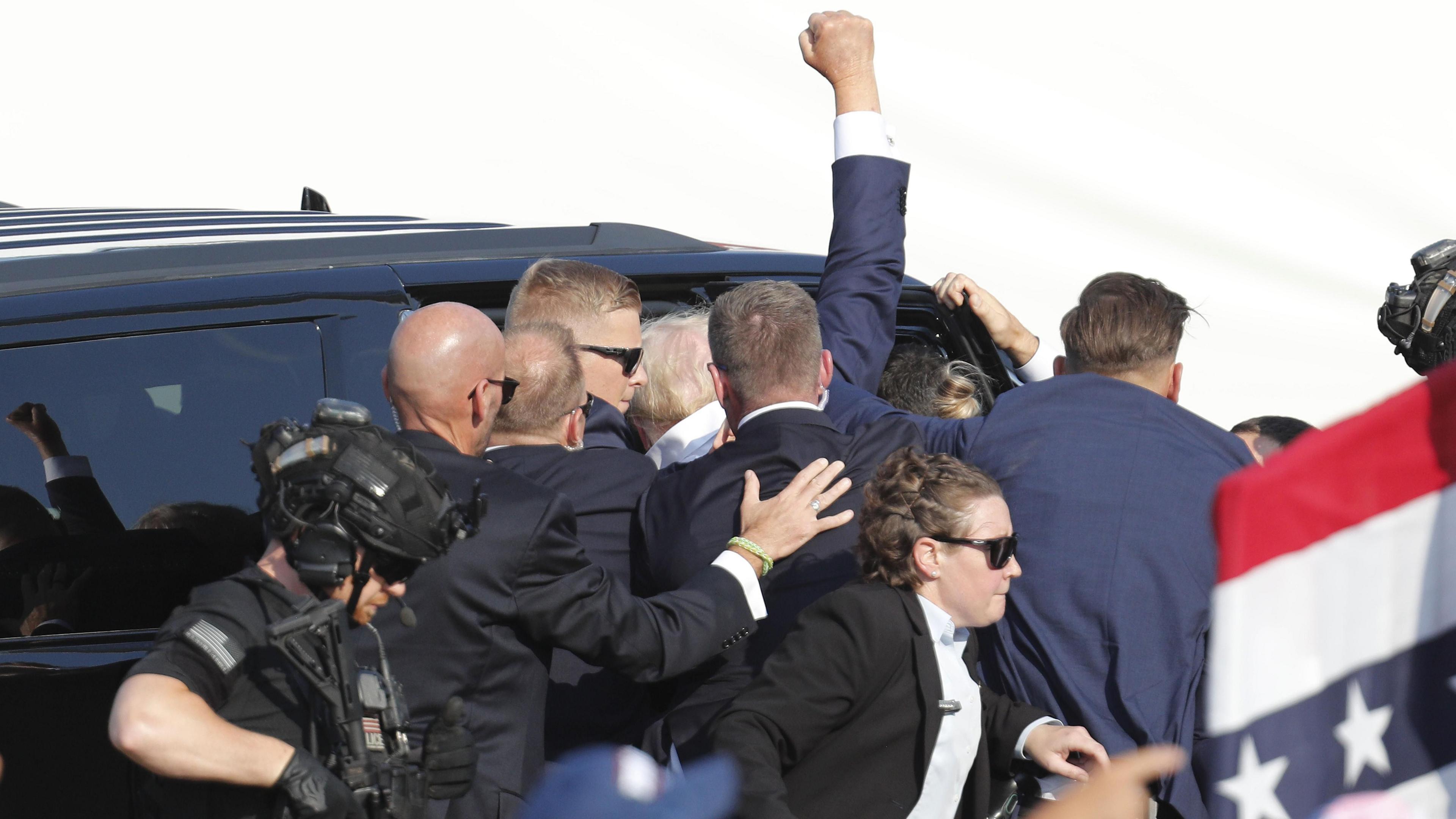 Donald Trump getting into his security vehicle after the shooting, with his fist raised