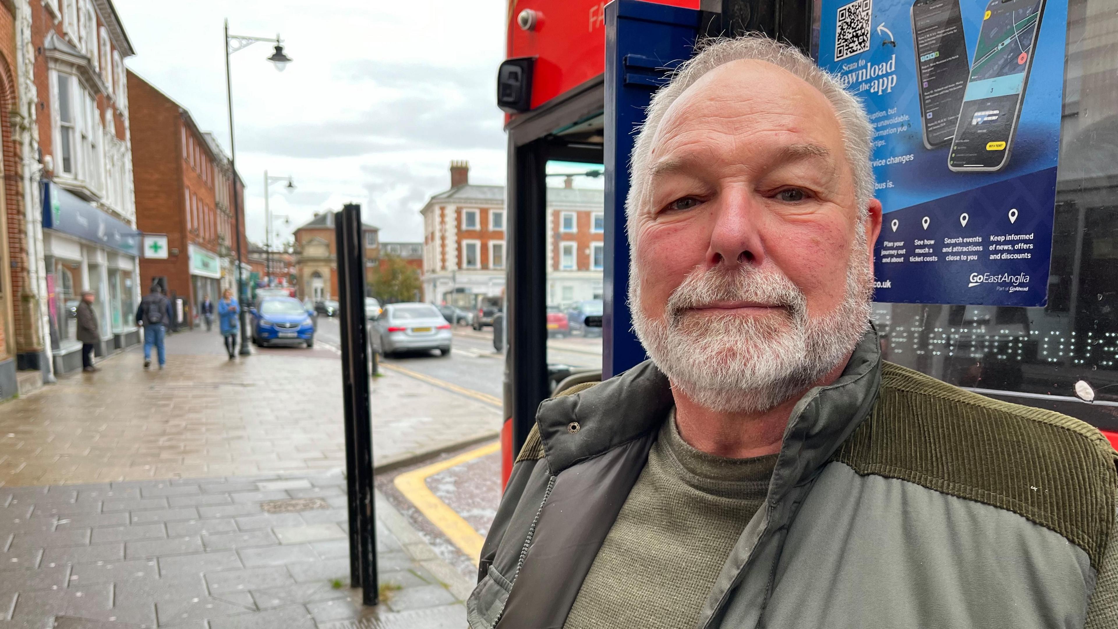 70-year-old Mick Biffen at a bus stop in Market Place in Dereham