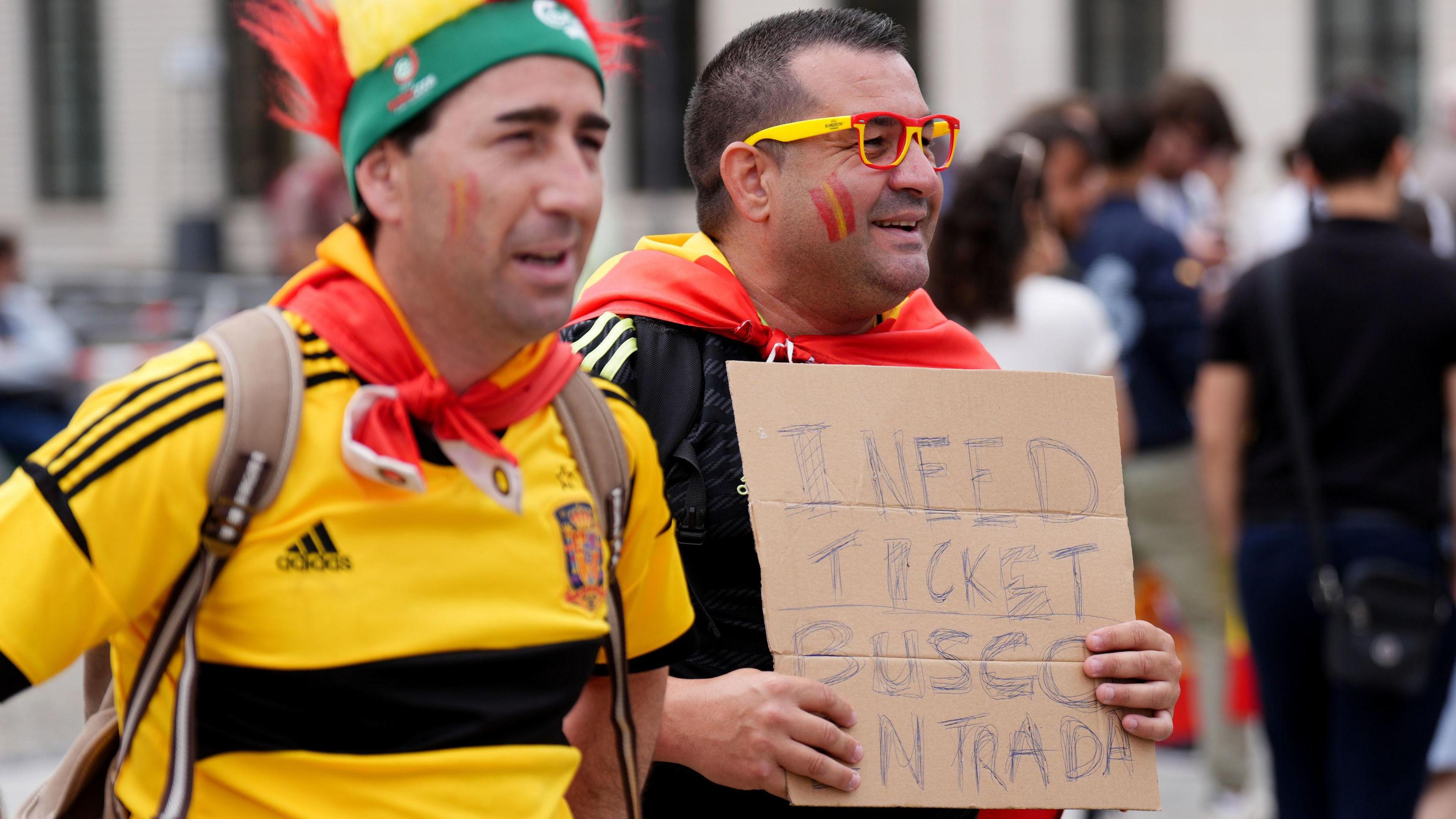 Spanish fan holds sign asking for a ticket to the game