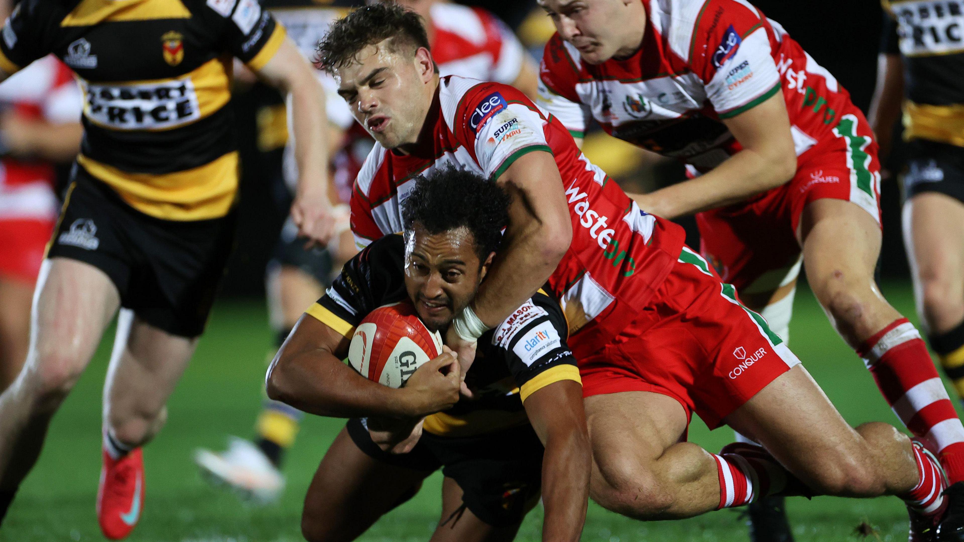 Jon Morris of Newport is tackled by Corey Baldwin of Llandovery