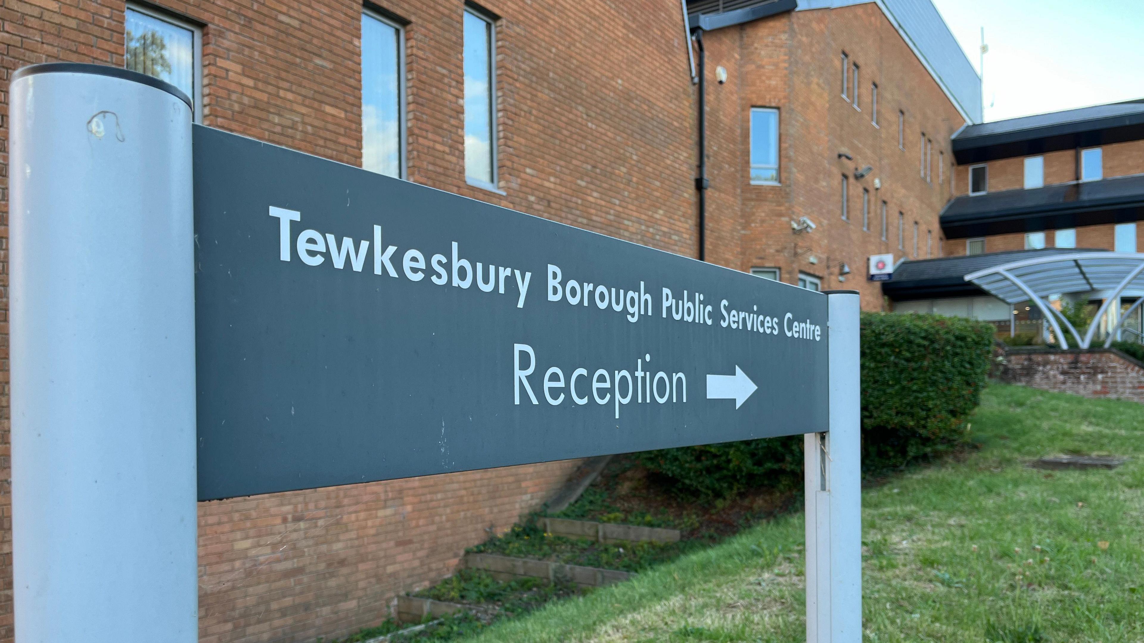 A sign for a council office with the word "reception" on it, in front of a council office