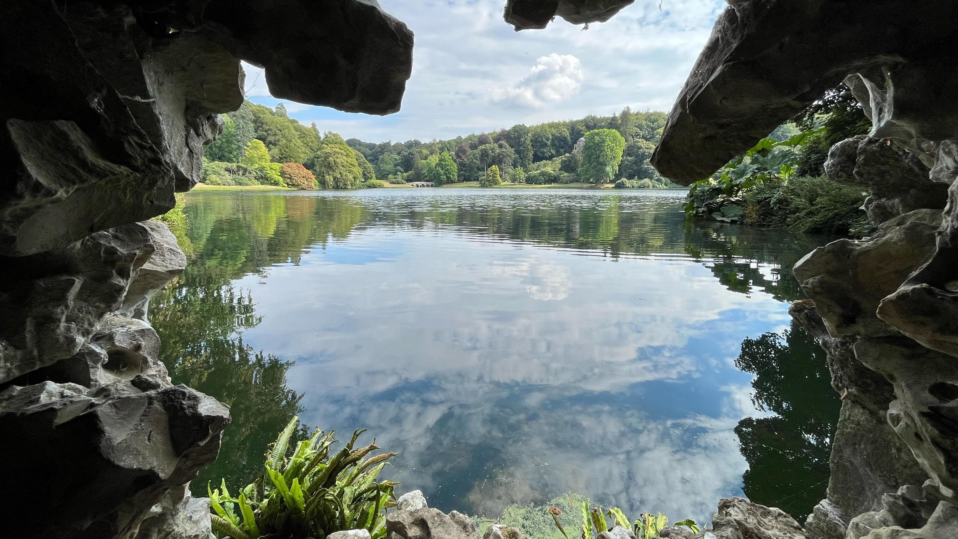 Grotto edge to the picture with stunning view across lake and blue sky