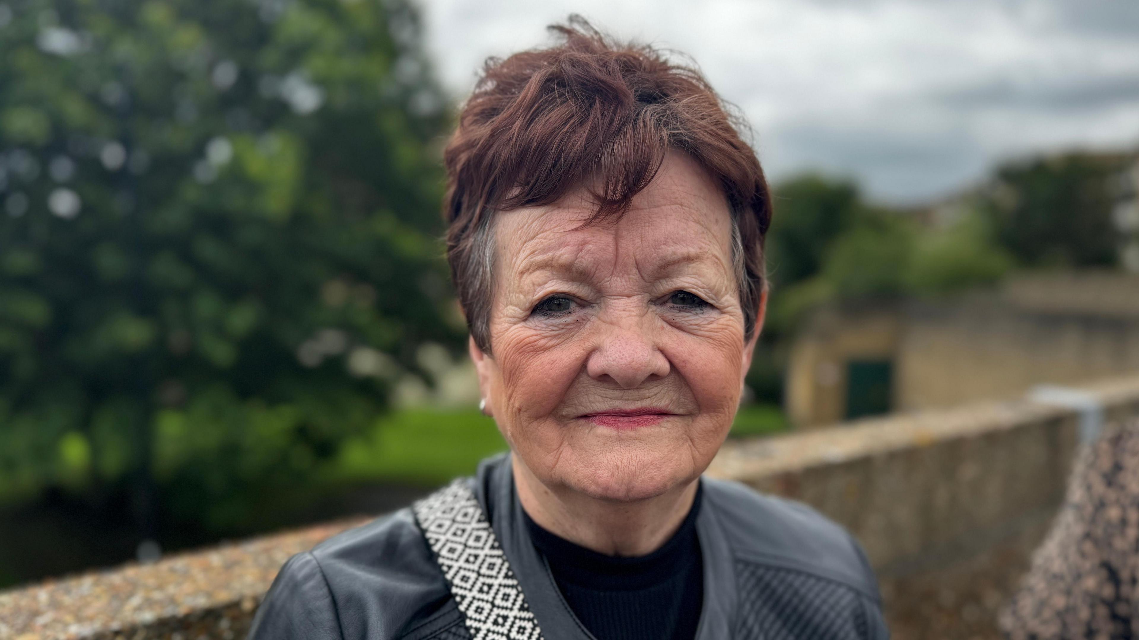 Gladys Dorman, who has short reddish grey hair and is smiling.