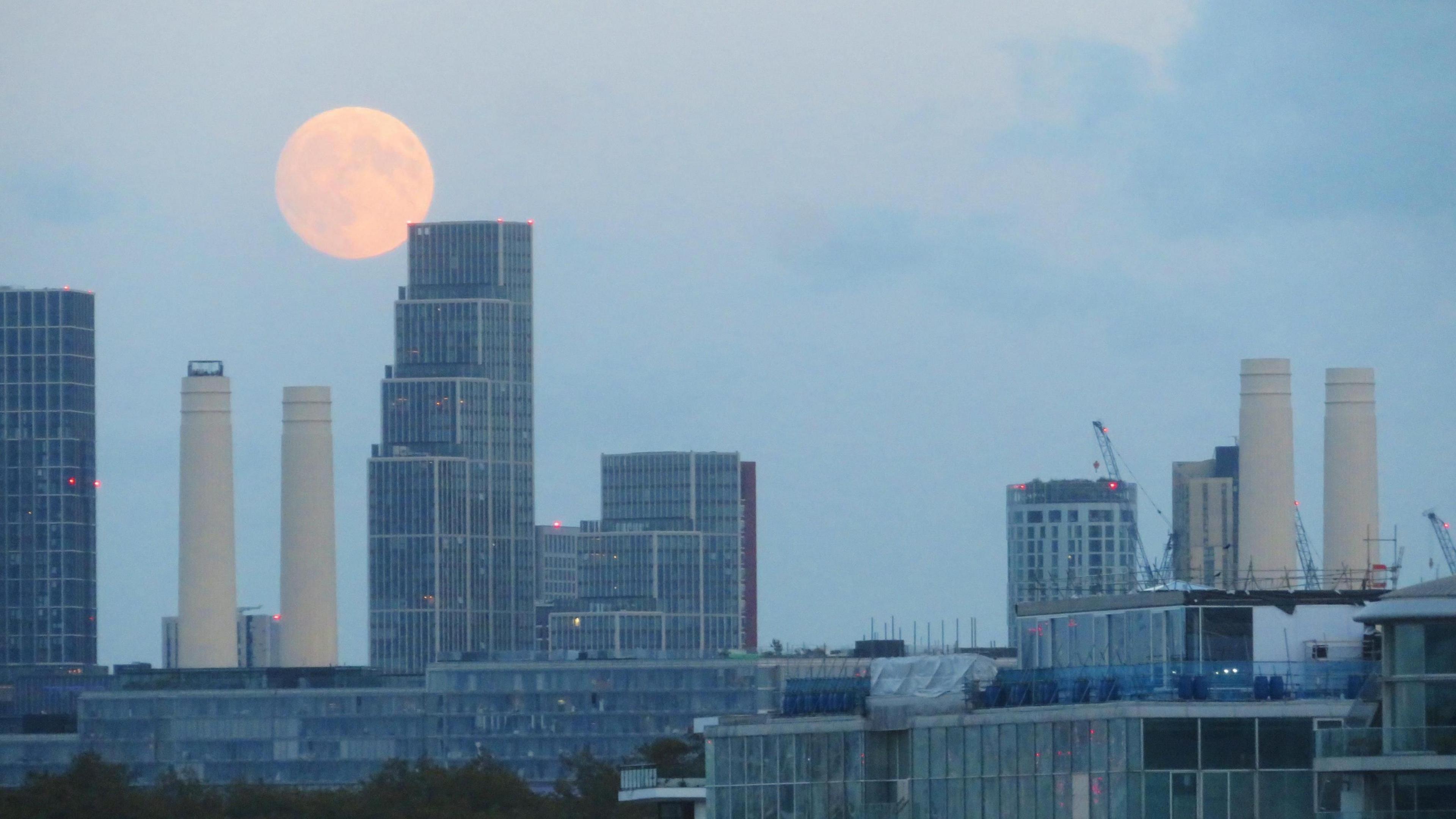 Full moon rising above the London skyline