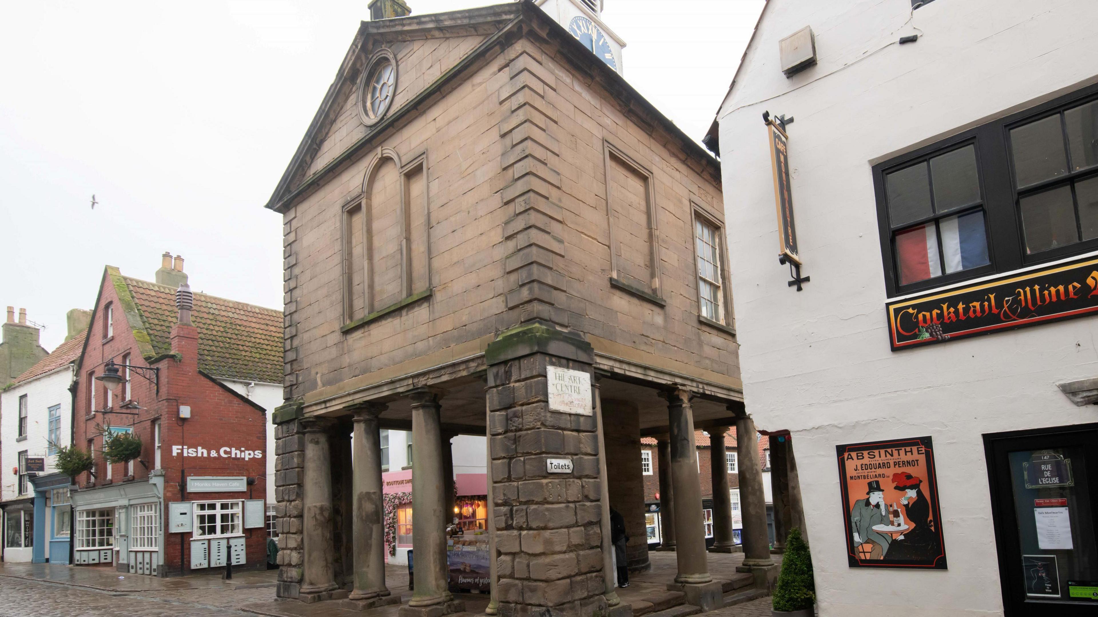 A side view of the Old Town Hall looking through its pillars.